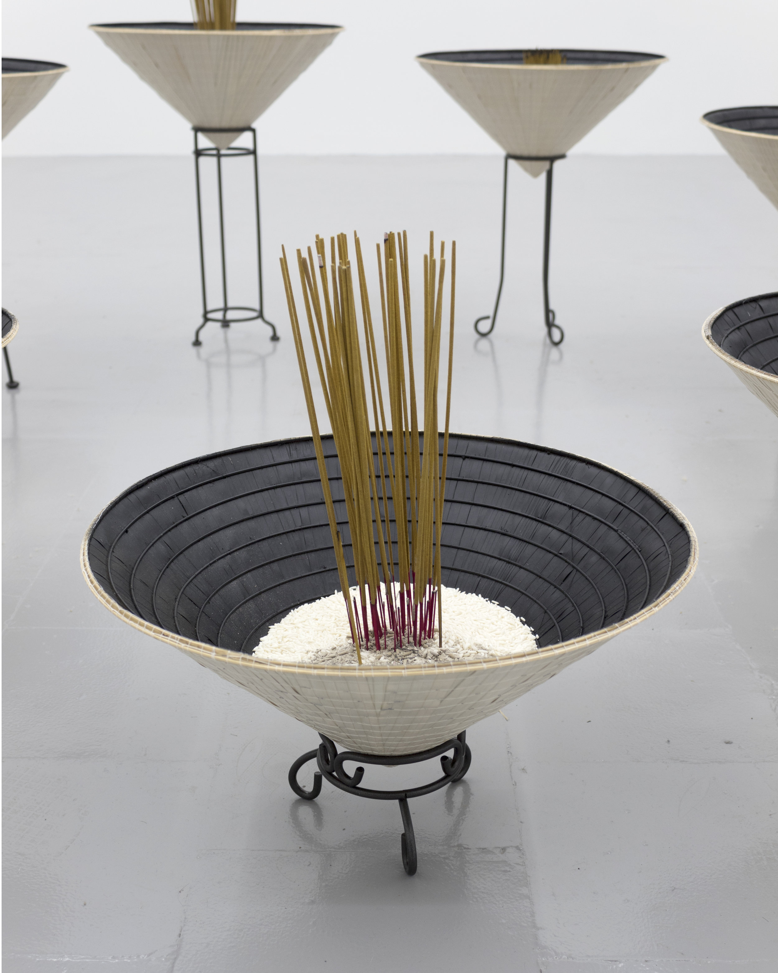  Millian Giang Lien Pham,  Reforge: 9 Phases (One),  2019. Conical hat, sweet rice, incense, metal stand 