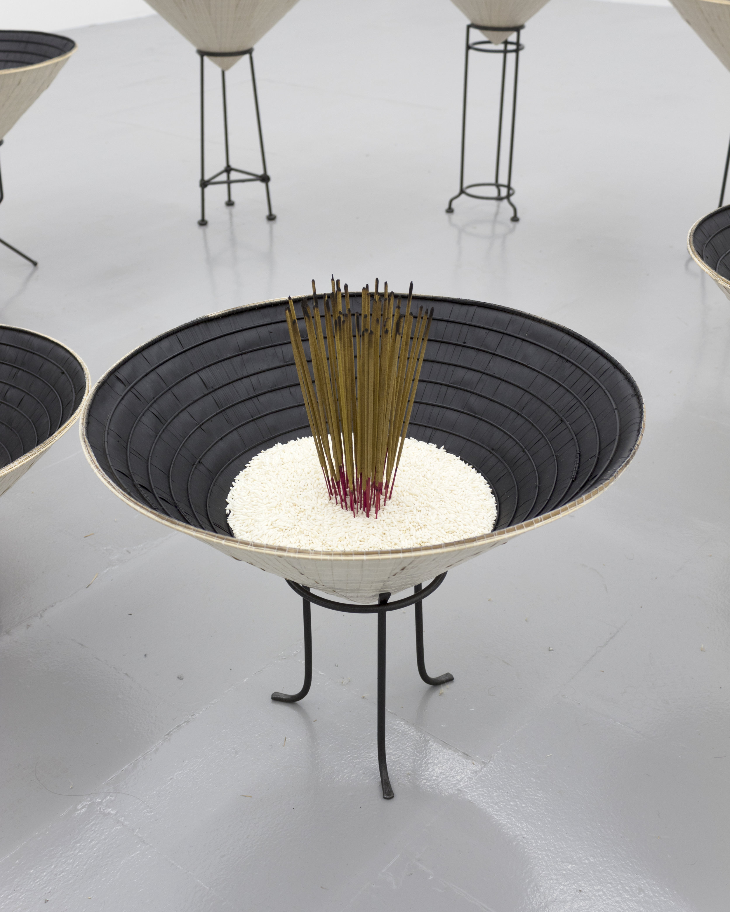  Millian Giang Lien Pham,  Reforge: 9 Phases (Two),  2019. Conical hat, sweet rice, incense, metal stand 