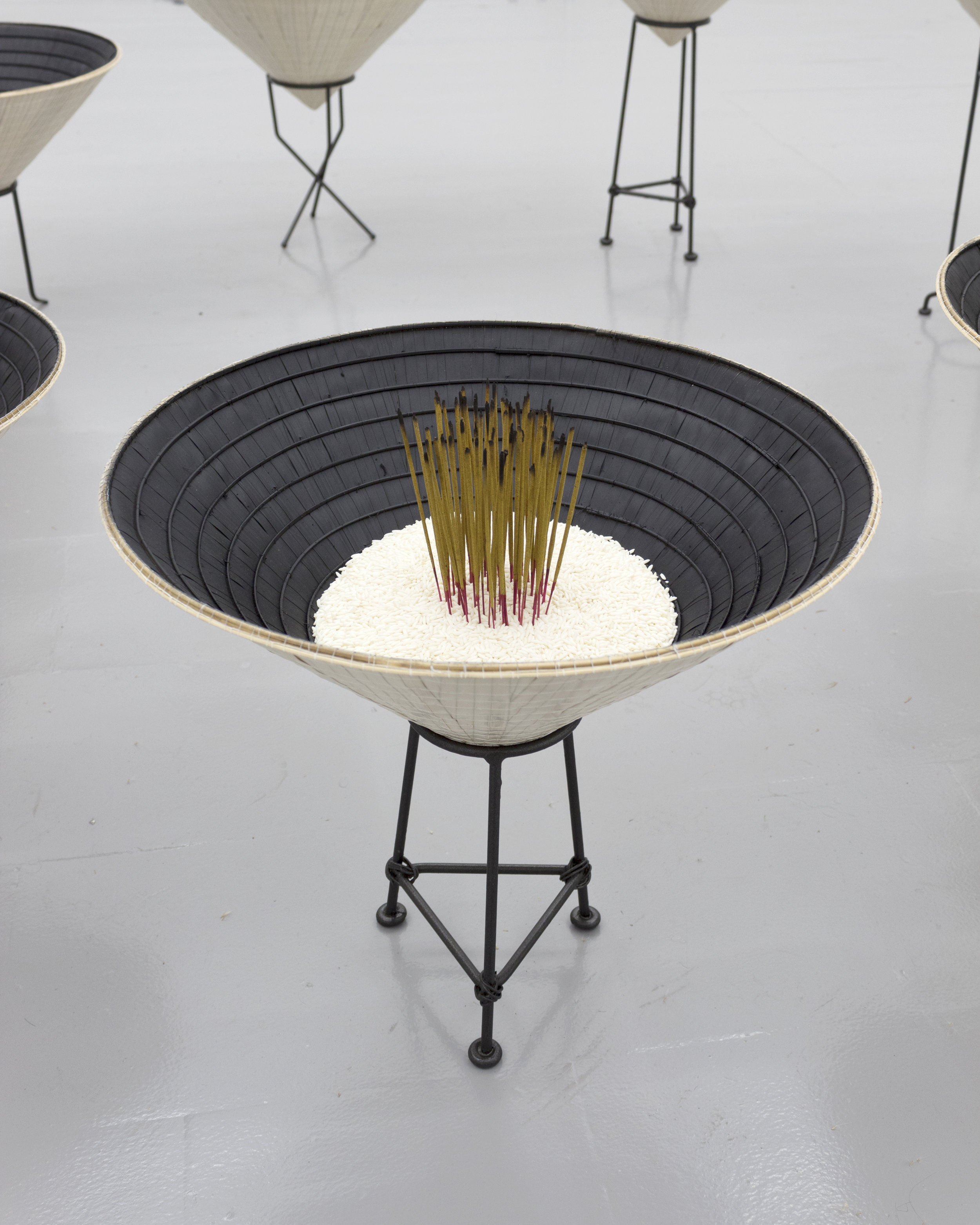  Millian Giang Lien Pham,  Reforge: 9 Phases (Three),  2019. Conical hat, sweet rice, incense, metal stand 