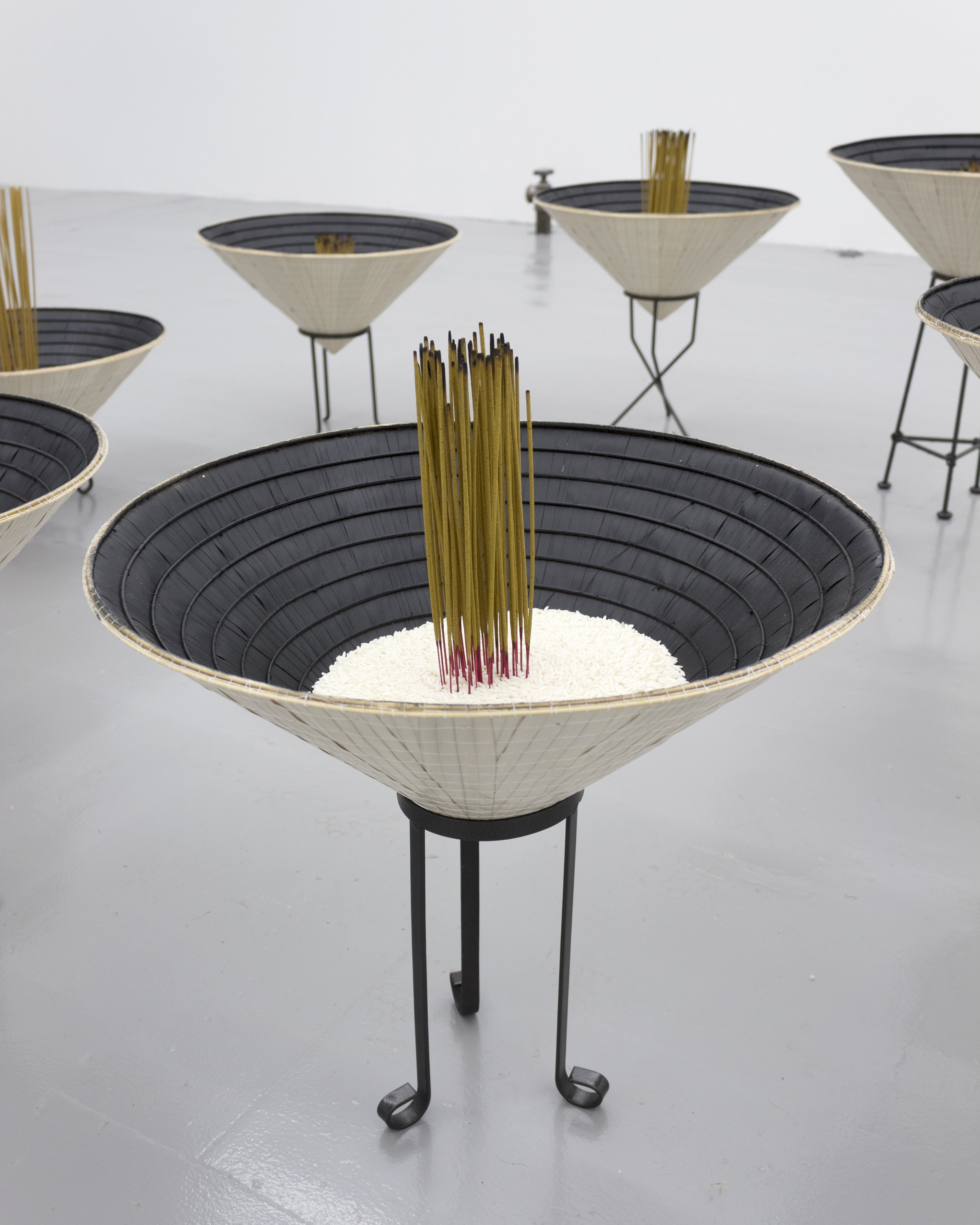  Millian Giang Lien Pham,  Reforge: 9 Phases (Four),  2019. Conical hat, sweet rice, incense, metal stand 