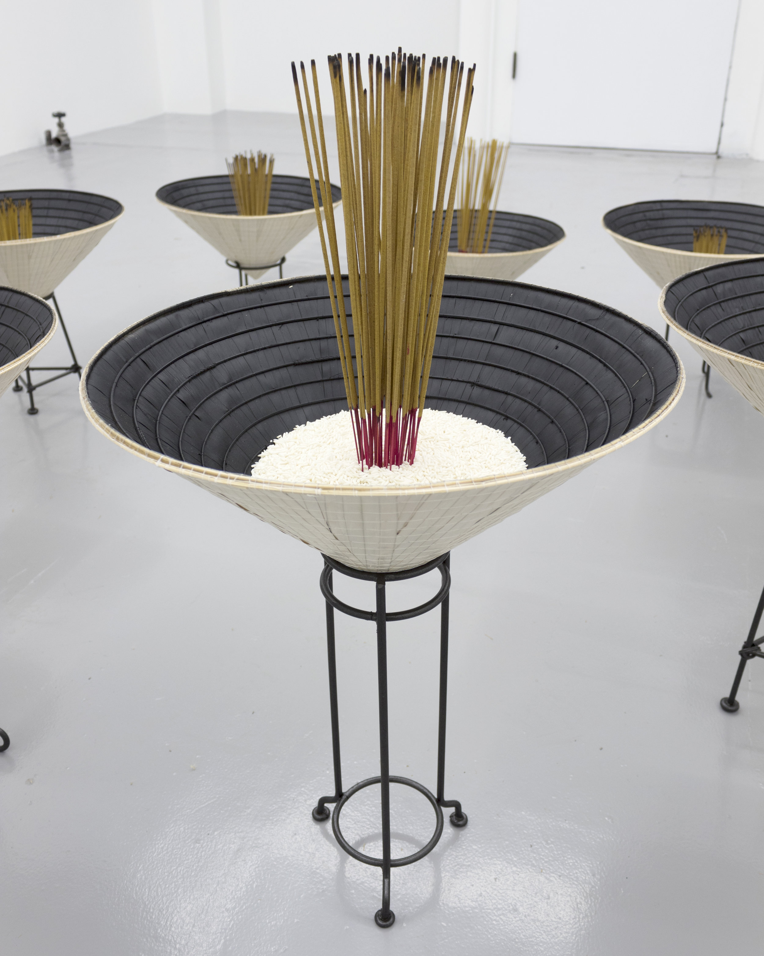  Millian Giang Lien Pham,  Reforge: 9 Phases (Six),  2019. Conical hat, sweet rice, incense, metal stand 