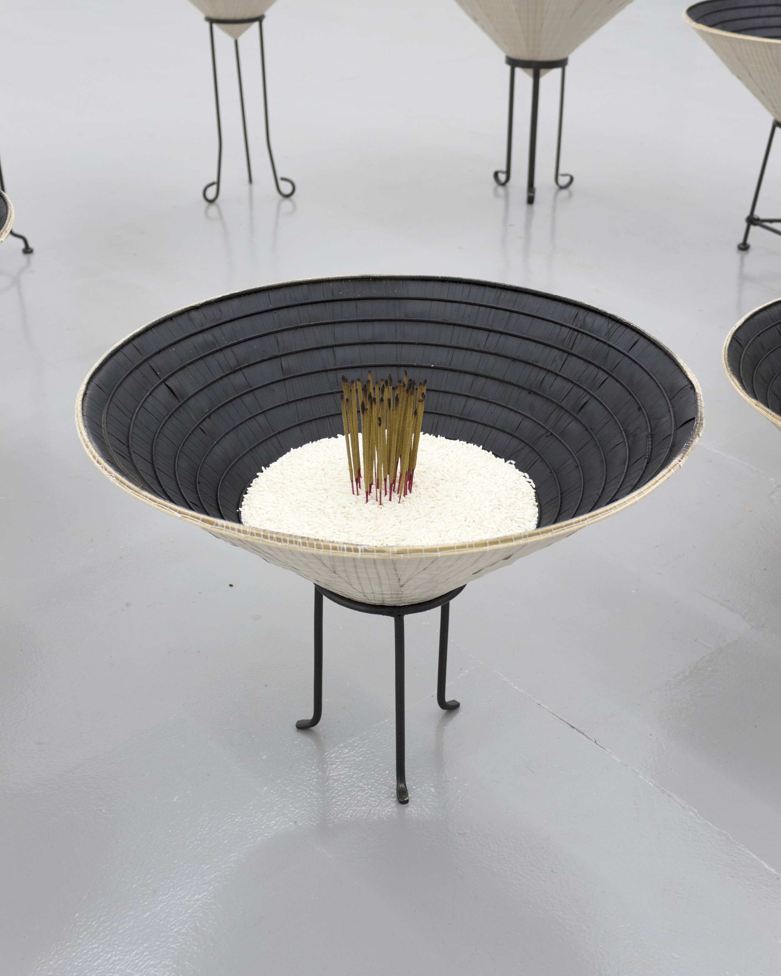  Millian Giang Lien Pham,  Reforge: 9 Phases (Nine),  2019. Conical hat, sweet rice, incense, metal stand 