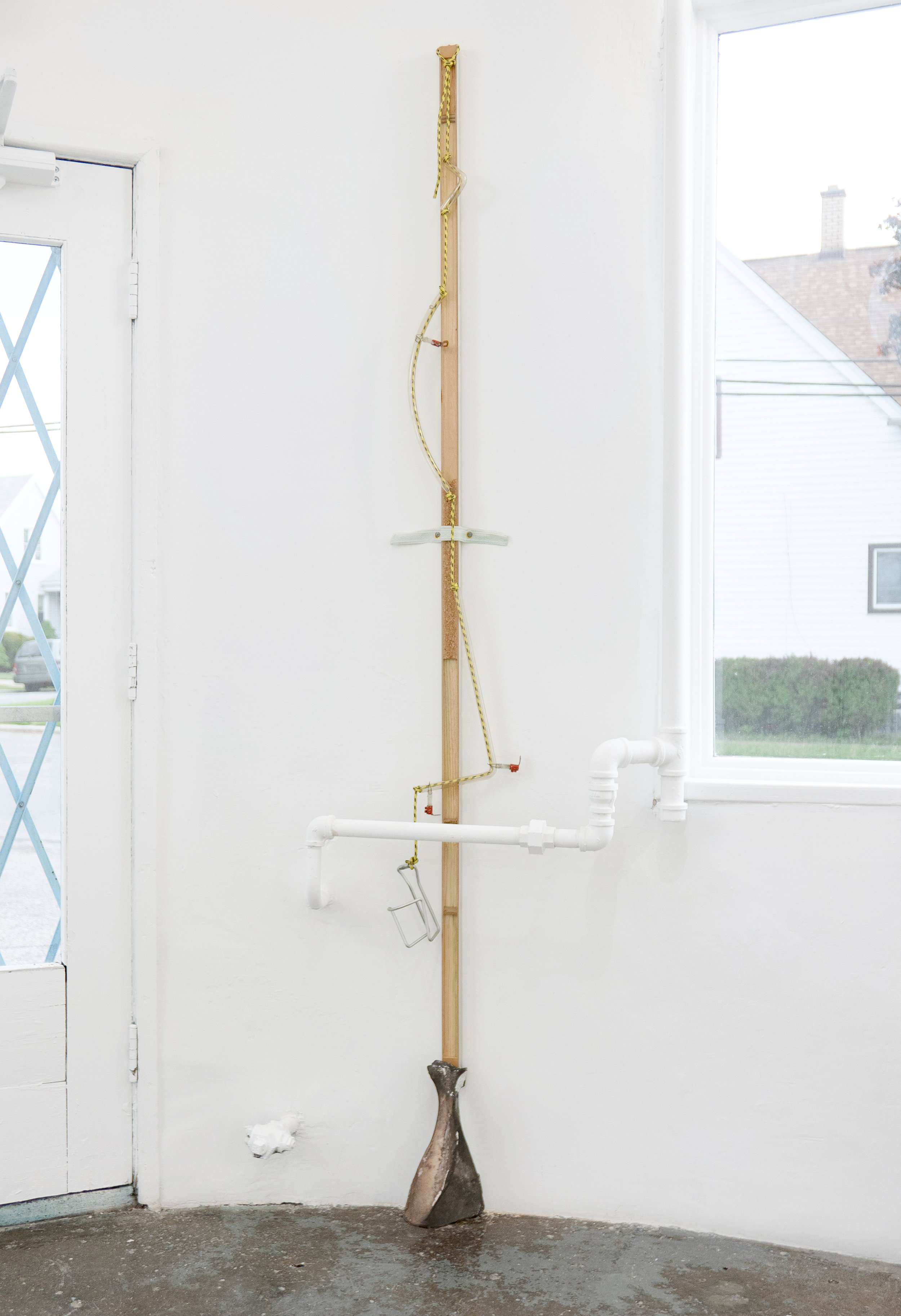  Matt Siegel,  W , 2018, Raw bronze, hollow core door, accessory cord, neon glass tubing (sourced: abandoned China Buffet, Evanston, WY), found object, earth, 92 x 8 x 5 in 
