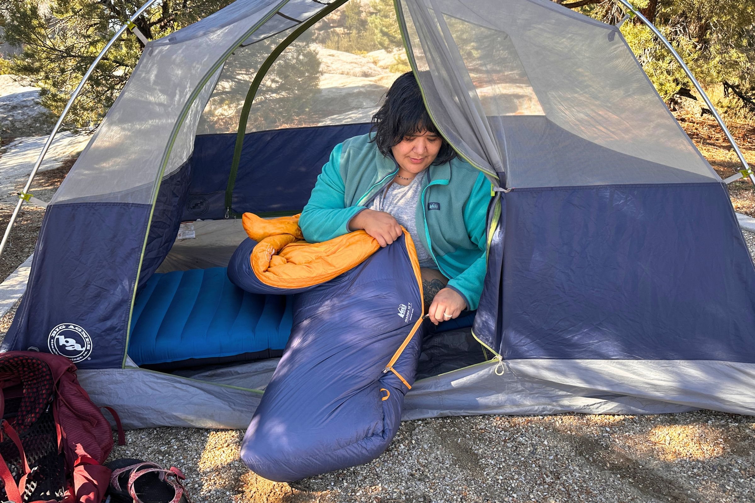 Zipping the REI Co-op Magma 30 while seated inside of it.