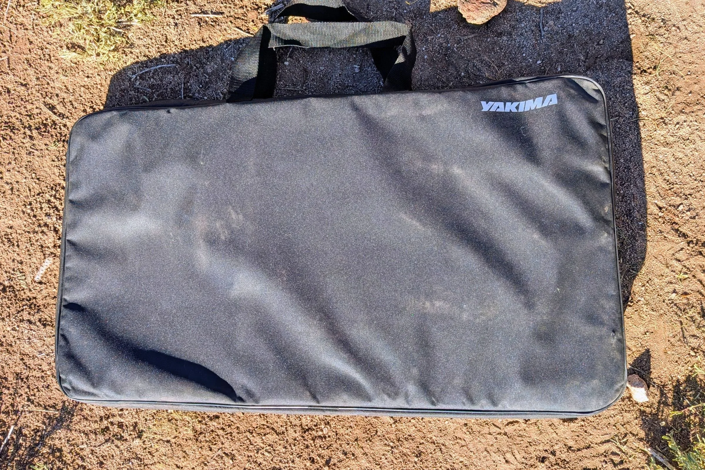 Yakima EXO OpenRange metal side table packed in a black storage case on dirt.