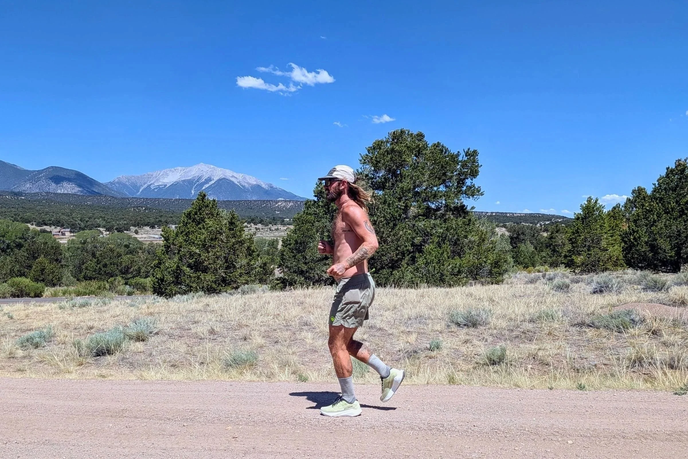 Man wearing the rabbit FKT running shorts with the Colorado Rockies in the background