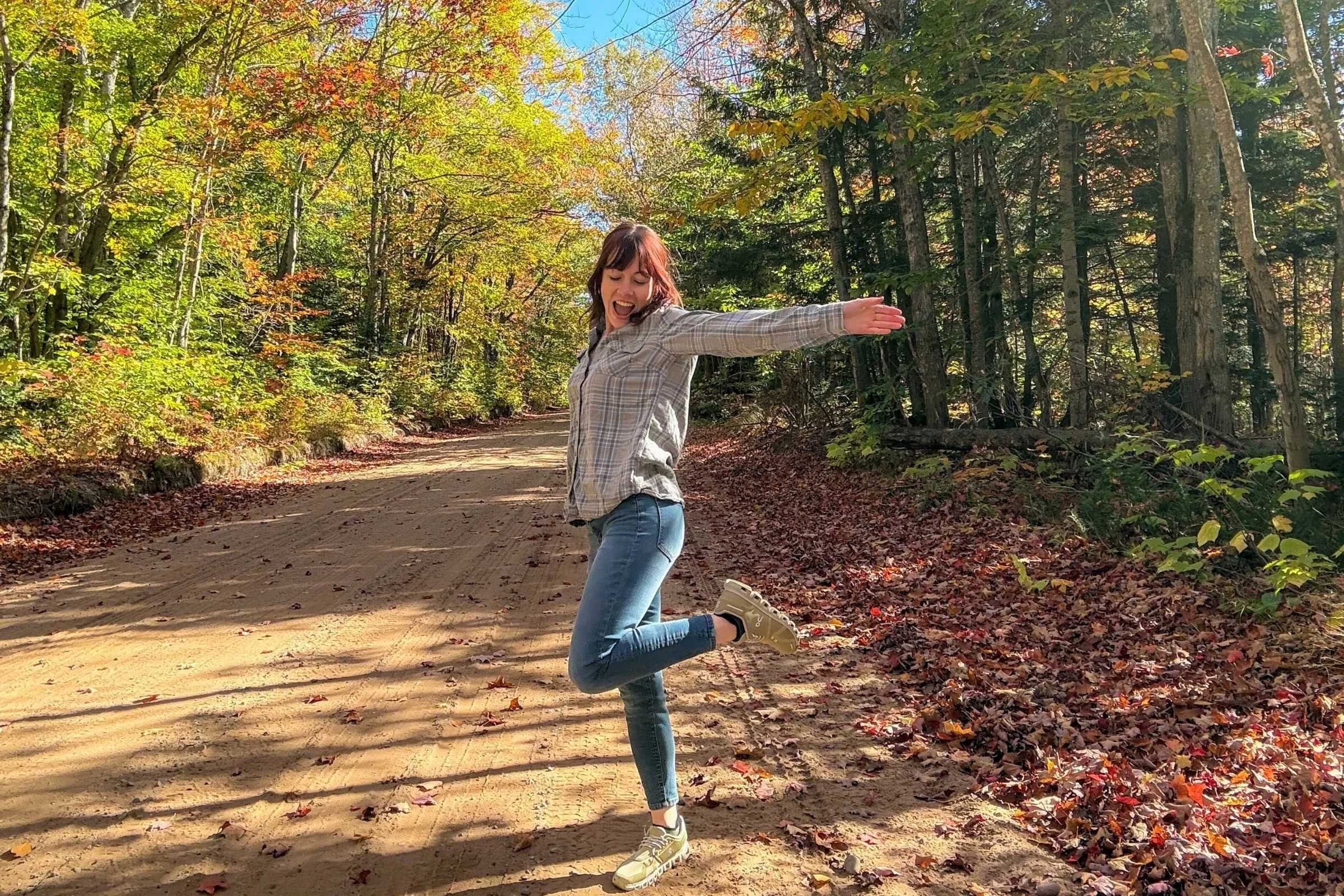 woman walks on dirt road wearing green on cloud 6 shoes