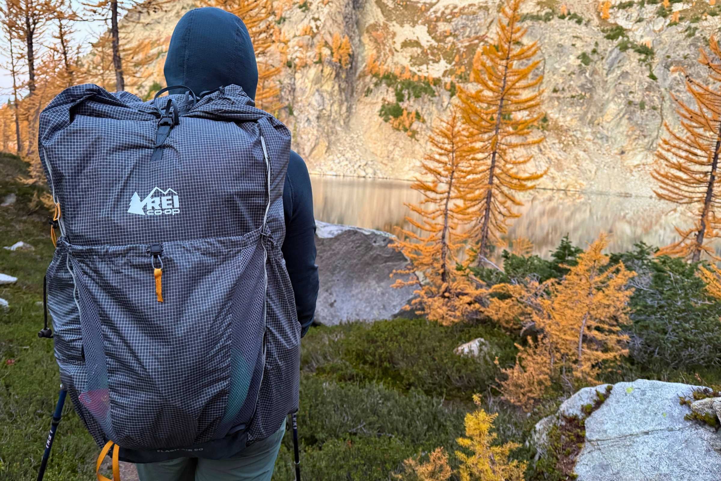 Naomi Hudetz wearing the REI Co-op Flash Air 50 backpack in North Cascades National Park with an alpine lake in the background