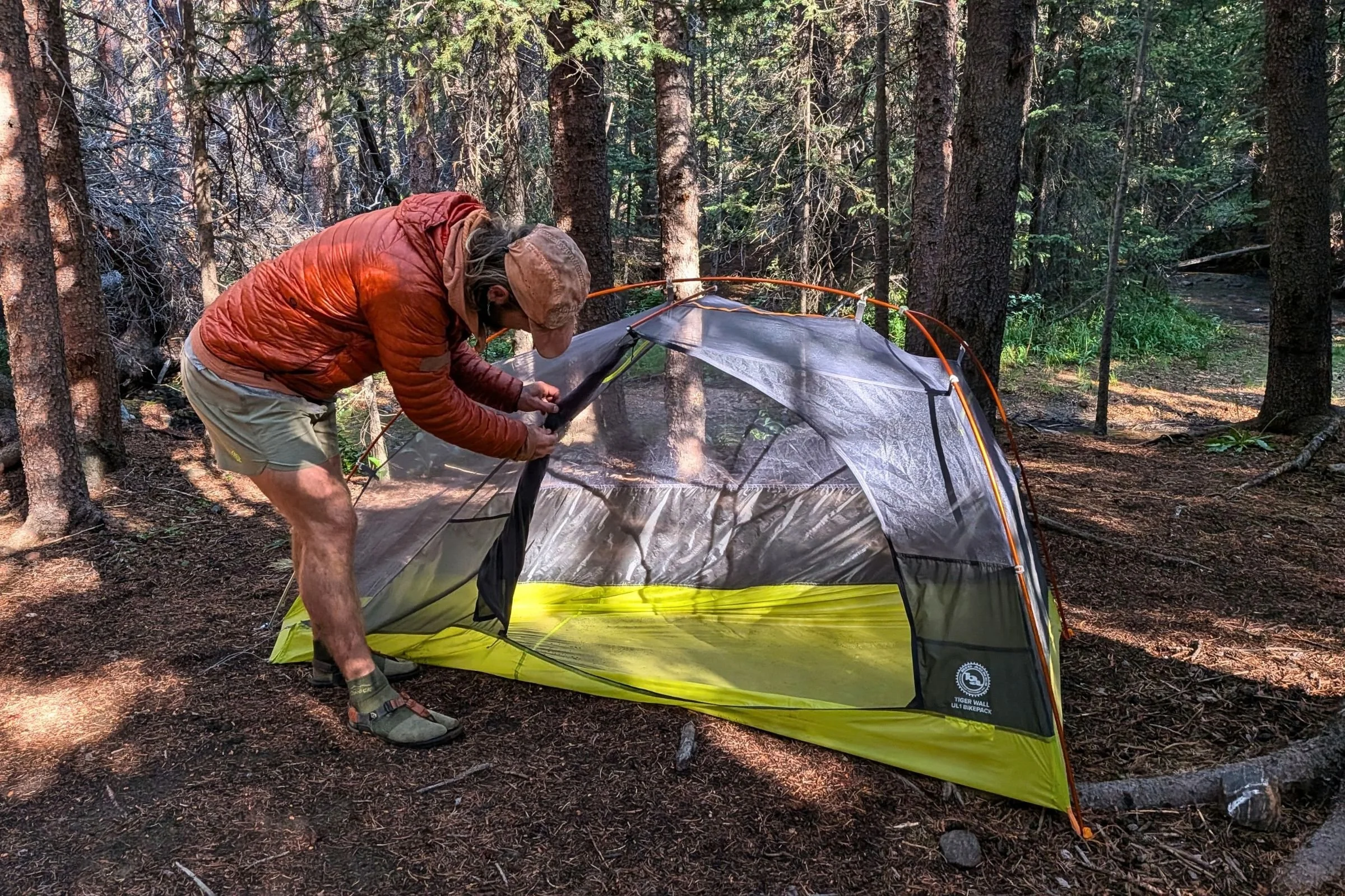 The author setting up the Big Agnes Tiger Wall UL1 Bikepack Tent with a forest in the backgrouind.