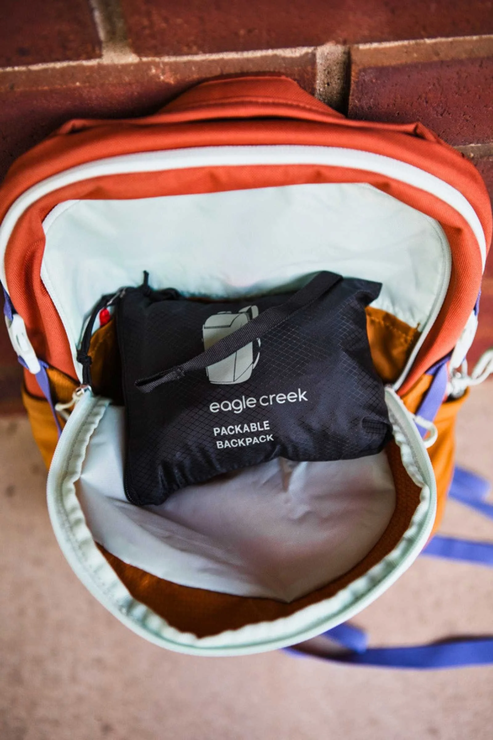 Image of the Eagle Creek Packable Backpack folded down and easily fits in a front pocket of a regular backpack