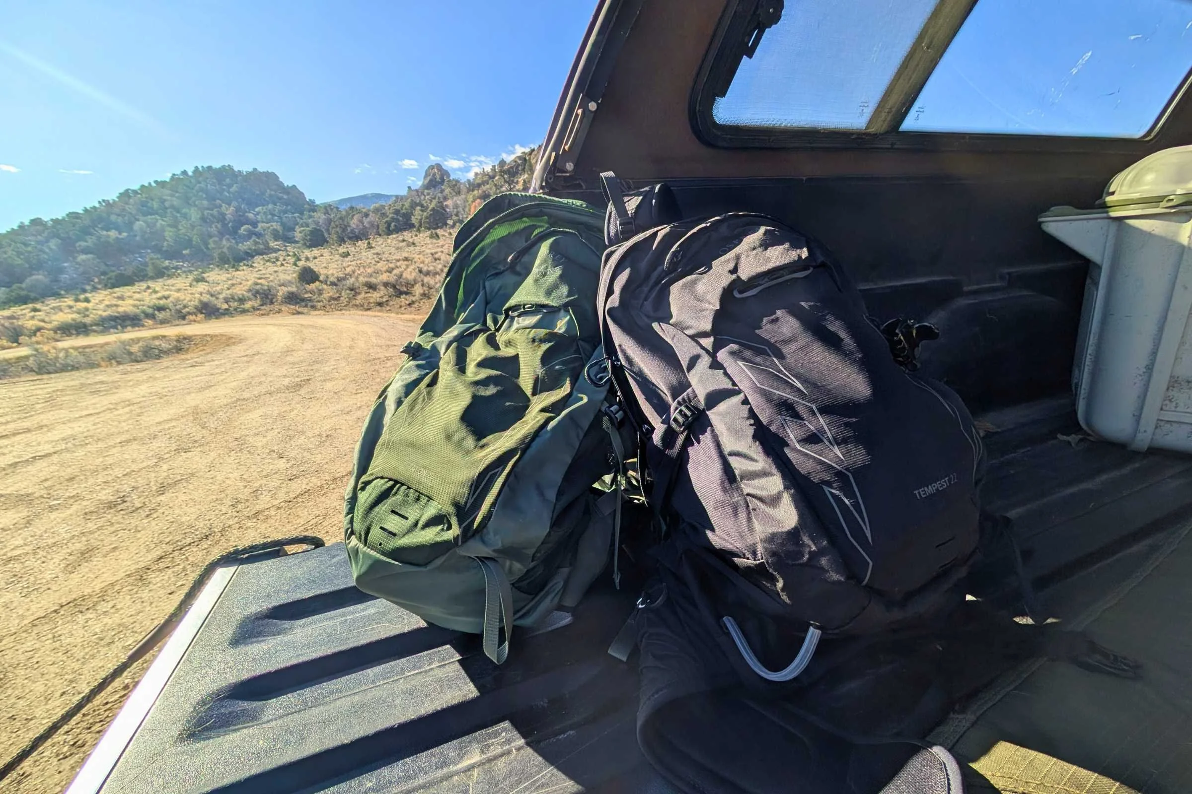 The Osprey Tempest and Talon sitting in the bed of a truck during a camping trip.