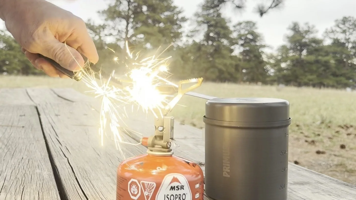 Sparks fly from the Gerber Stakeout Spark’s ferro rod above an MSR PocketRocket Deluxe stove.