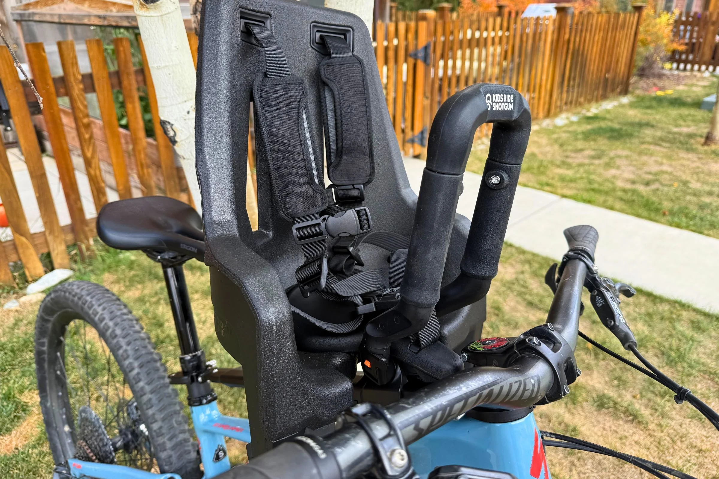 Close-up of the Kids Ride Shotgun Shotgun Pro Evo child seat attached to a blue mountain bike.