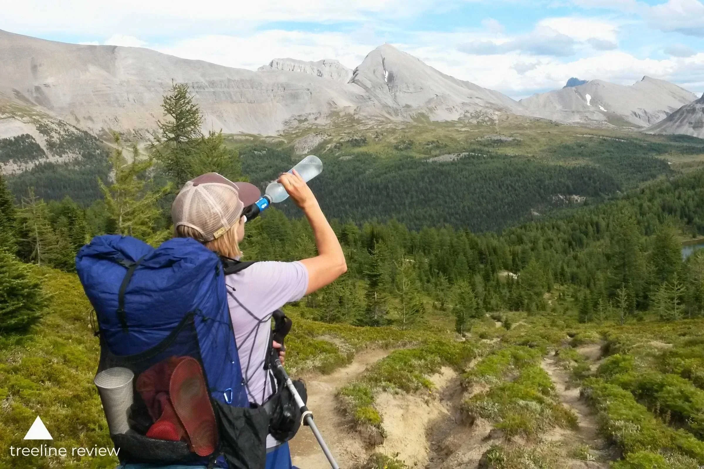 Person drinking through a Sawyer Squeeze water filter in the Canadian Rockies
