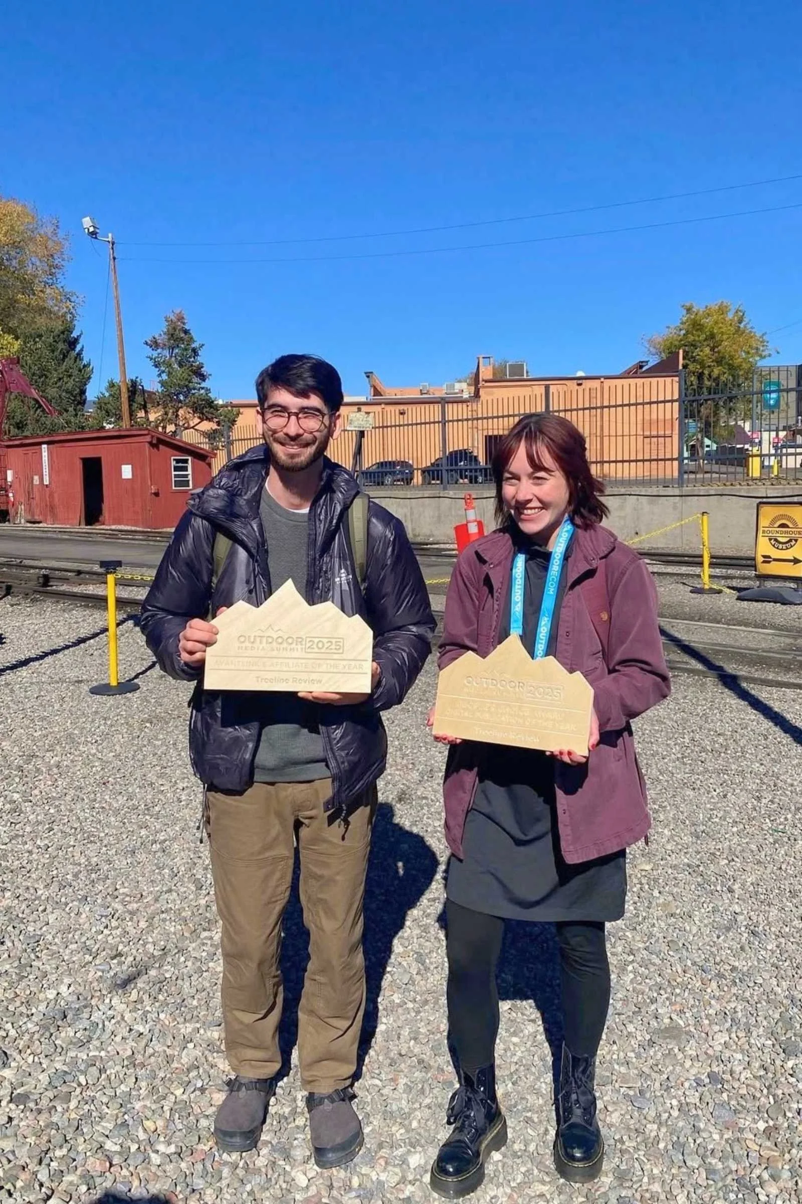 The author (right) holding up one of Treeline Reviews awards from Outdoor Media Summit while layering the Fjallraven Abisko Sun-Hoody Dress with tights and a jacket.