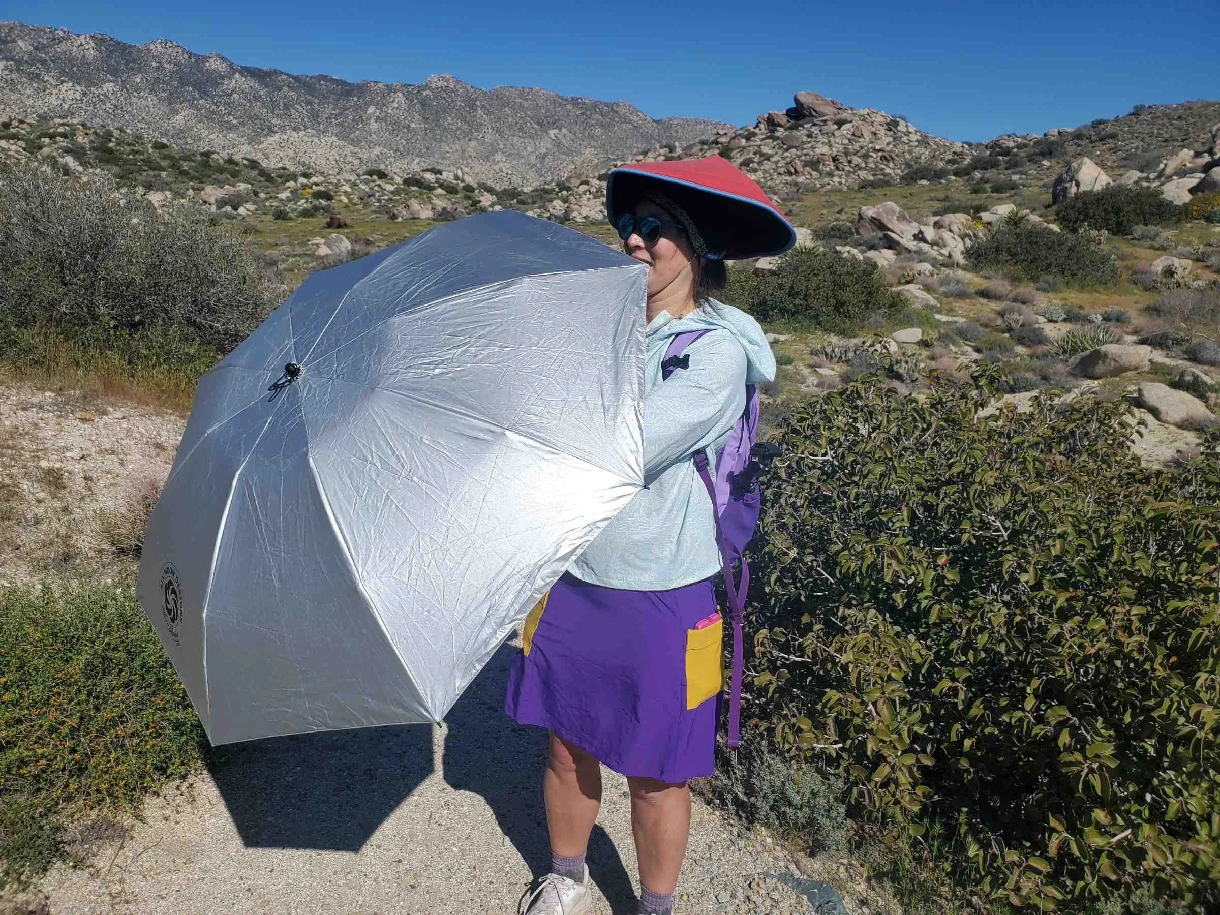 Treeline Review writer Liz Thomas hiking with the Six Moon Designs Collapsible sun umbrella on a windy day in Anza Borrego Desert.