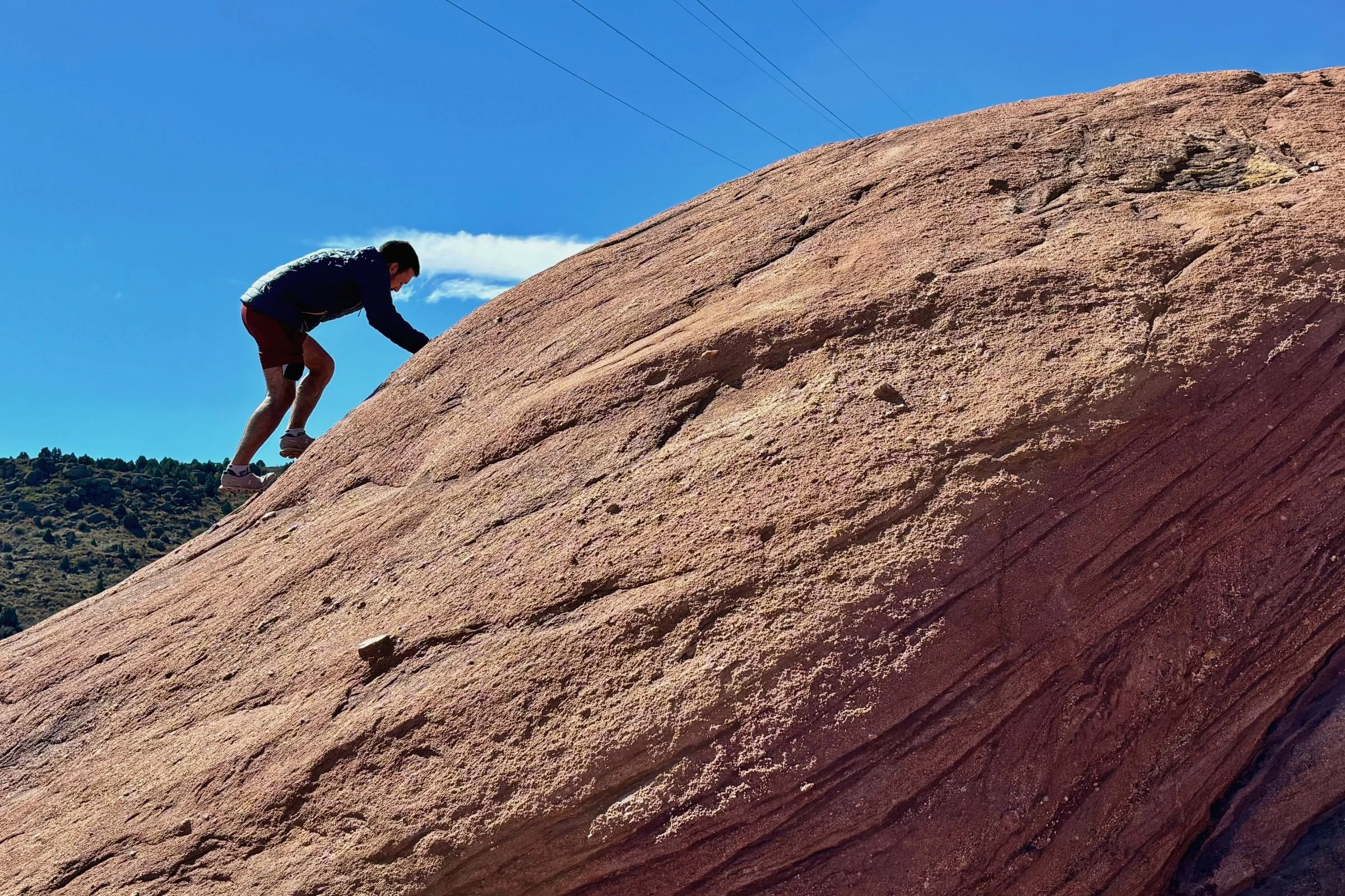 Man wearing Patagonia Nano Puff jacket, climbing up a rocky slope.