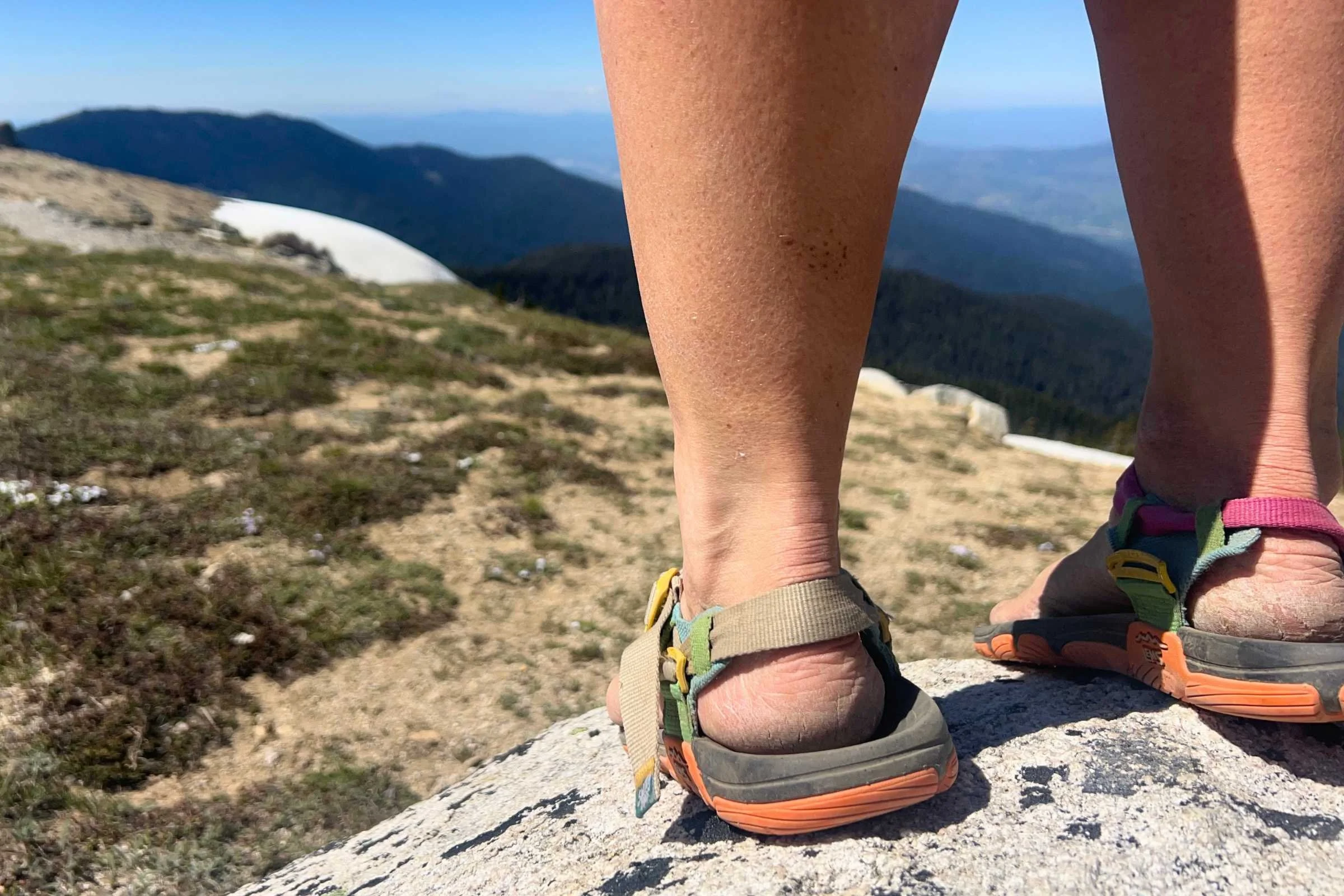 Standing on a rock outcropping in the Lems Switchback Sandal Knit