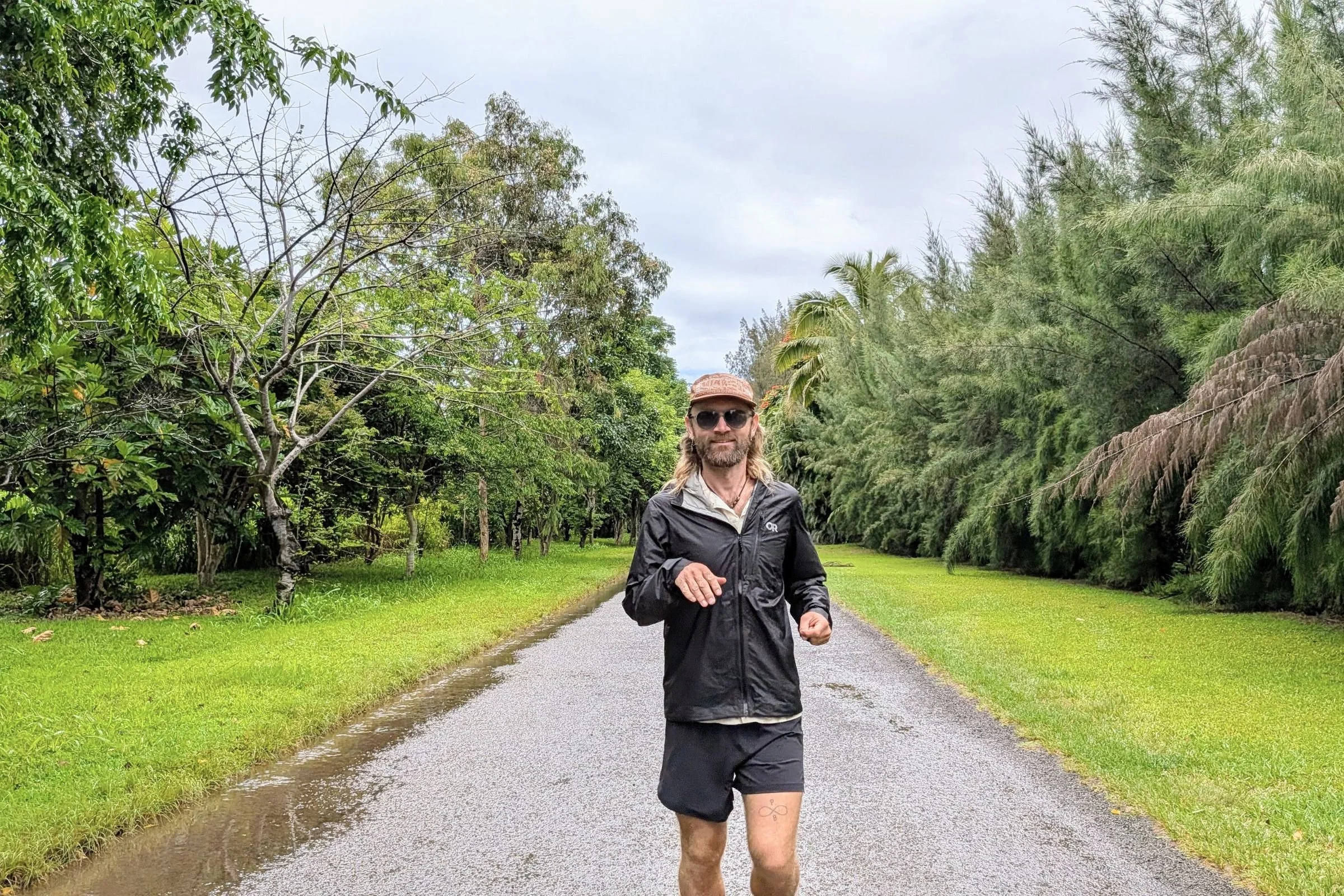 Tracksmith Twilight Running Shorts worn by a runner on a rainy paved road.