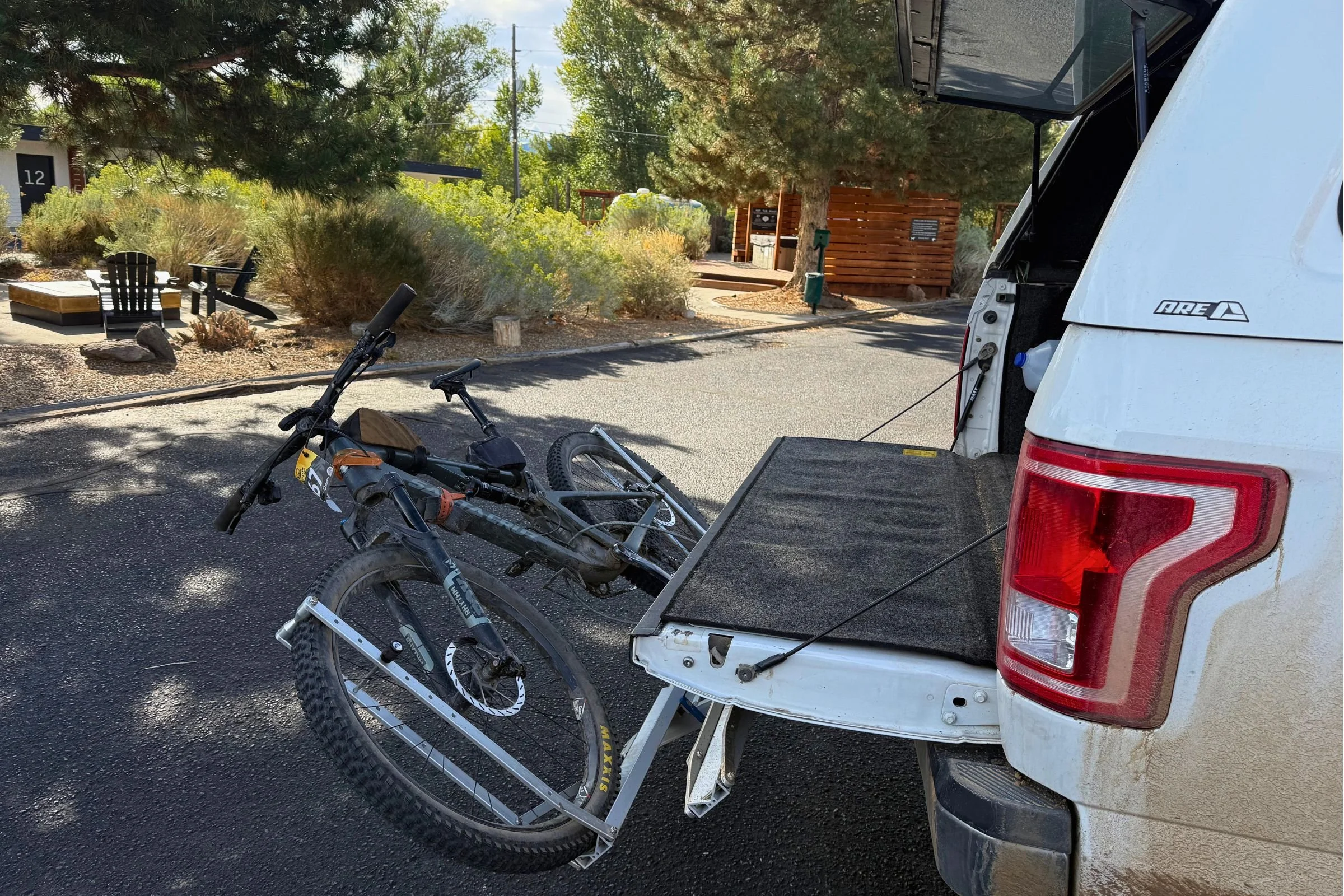 Bicycle mounted on the 1UP USA Heavy Duty Hitch Bike Rack at the rear of a truck, showing access to the vehicle.