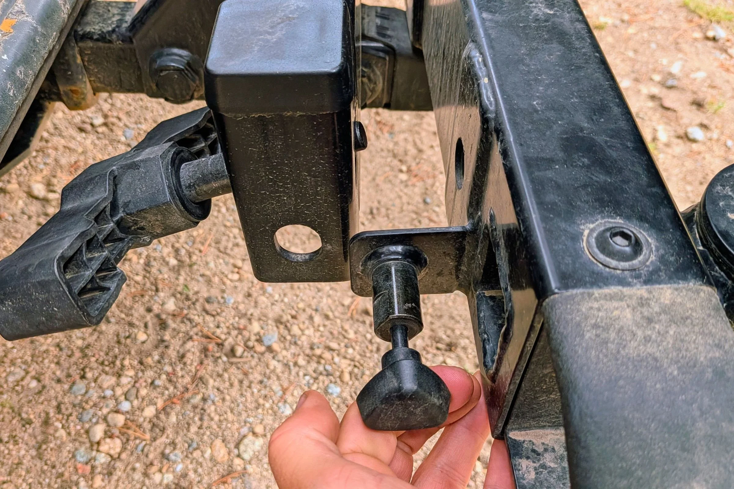 A person grasps the handle of a Yakima EXO Swing attached to a truck.