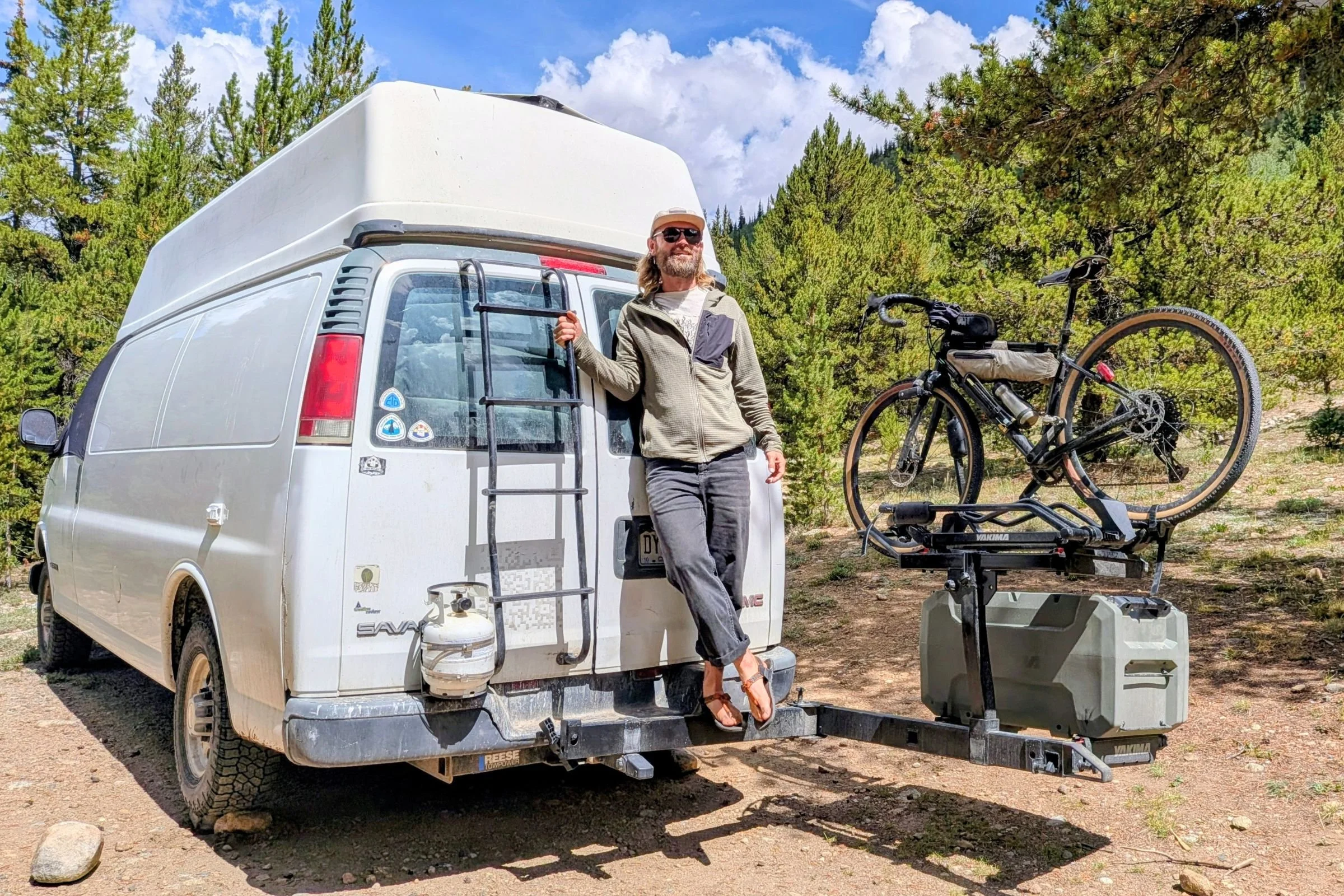 A man stands beside a van with a bike mounted on a Yakima EXO DoubleUp 2-Bike Hitch Rack.