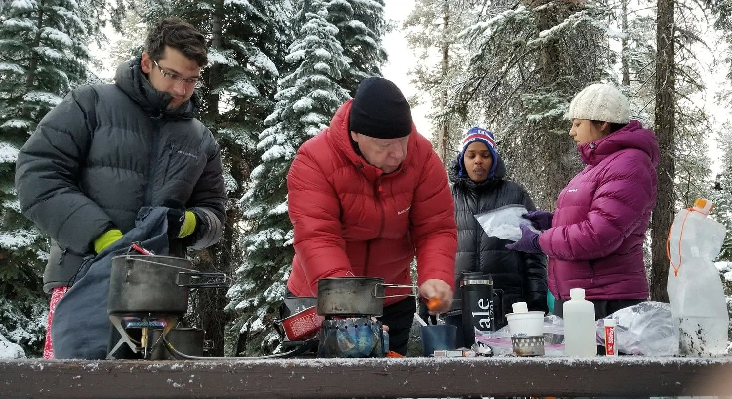 A variety of stoves being tested on a snowy cold morning.