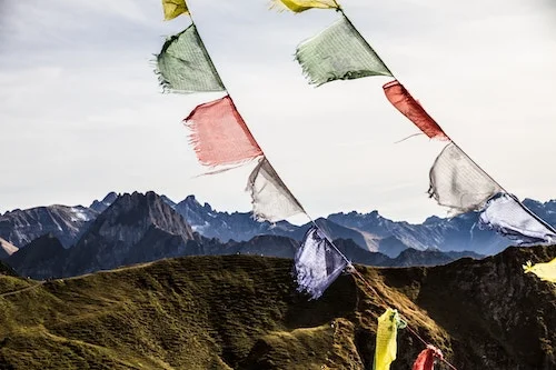 Prayer flags with mountains in the background.