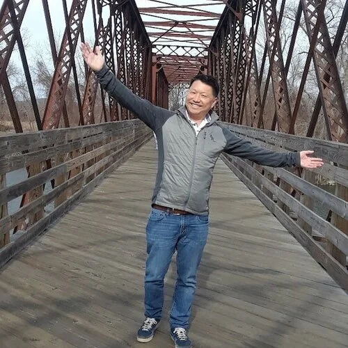 Kevin Tatsugawa standing on a bridge.