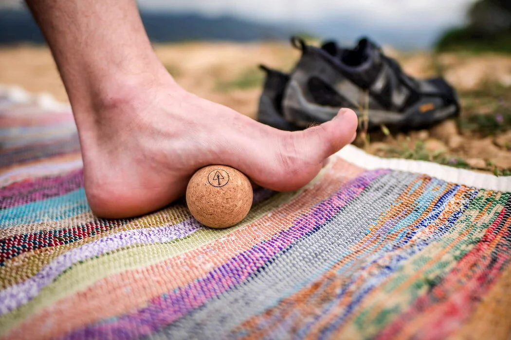 The Rawlogy cork massage ball being used on a foot.