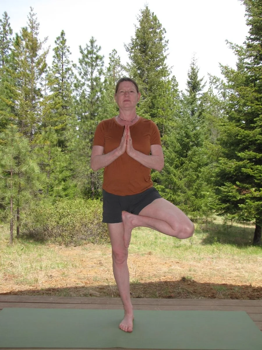 Hiker doing tree pose on trail