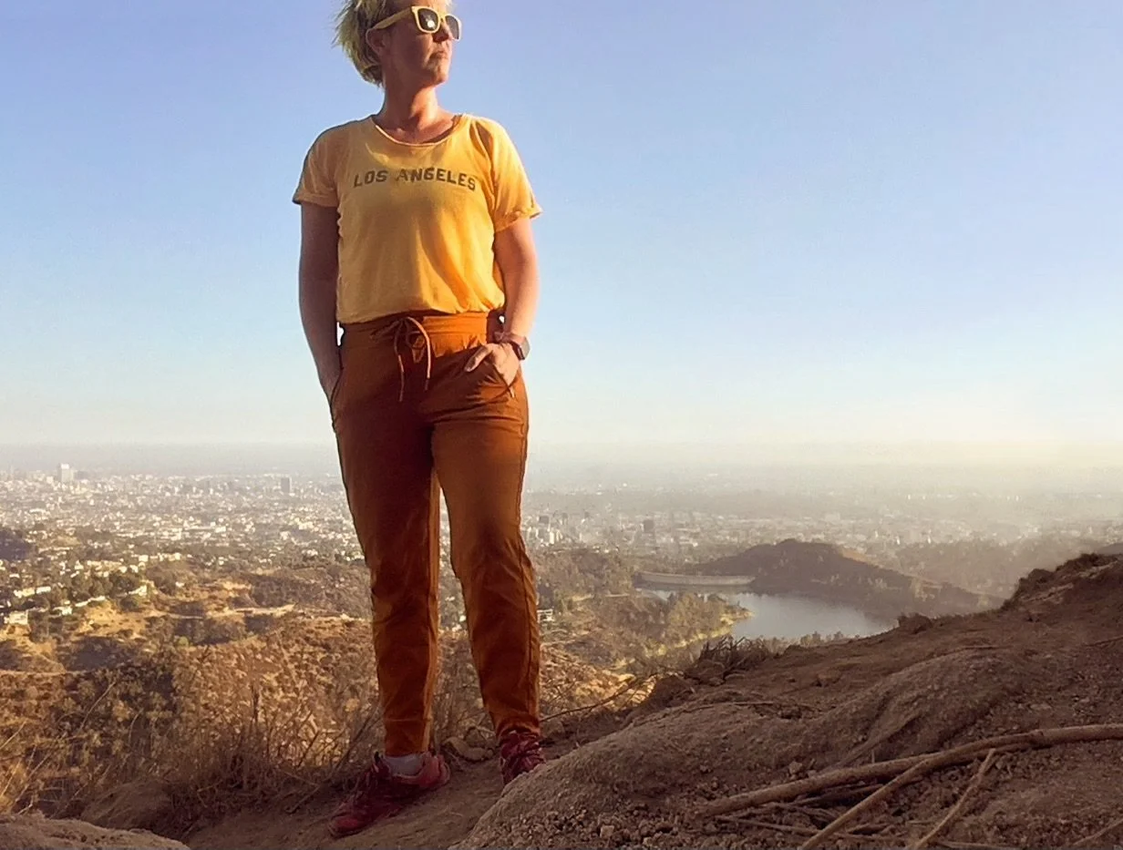 Woman standing on a hillside overlooking a city wearing Athleta Trekkie North Jogger hiking pants.