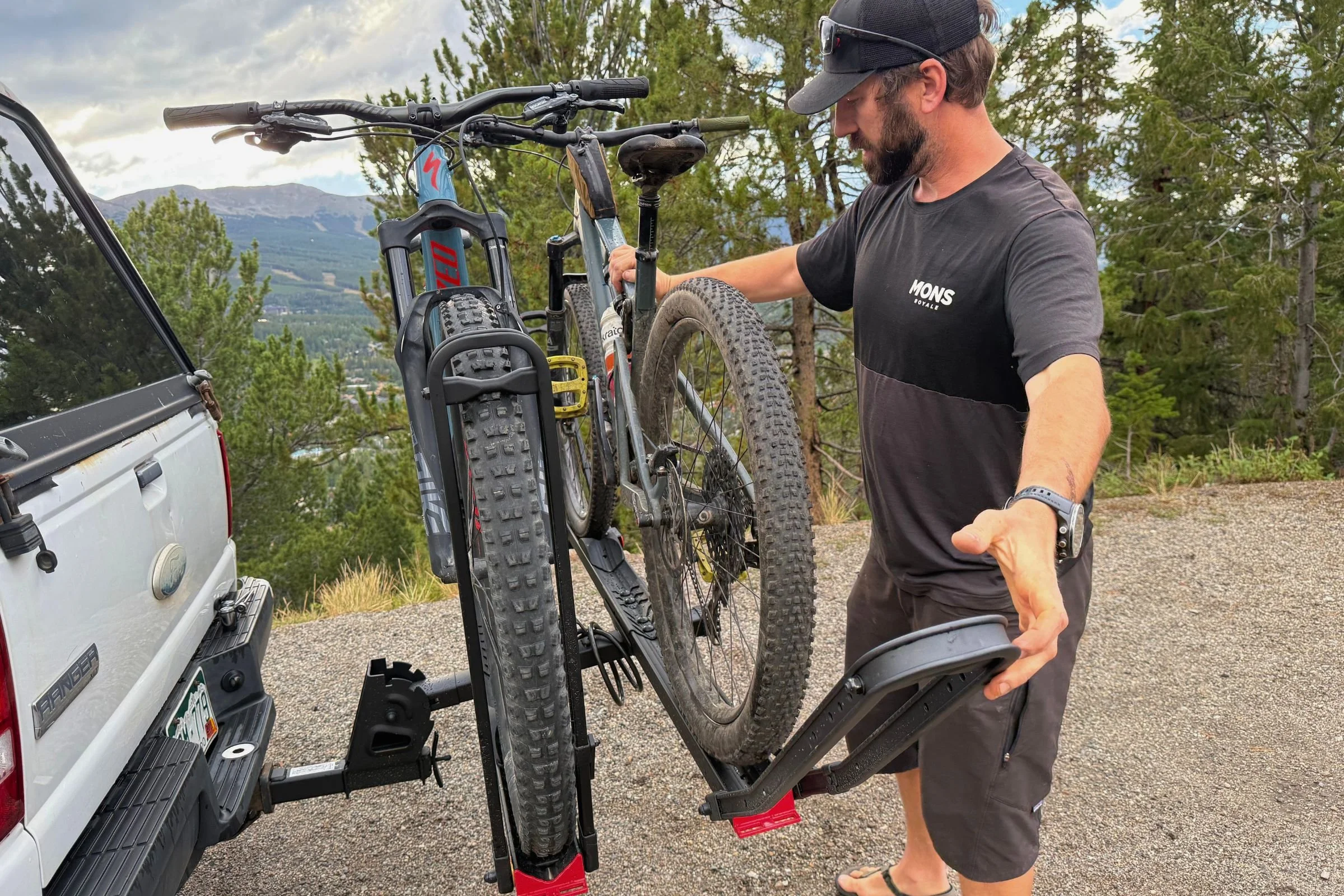 A person positioning a bike on a Hollywood Racks CrossTrack Hitch Bike Rack to demonstrate spacing between multiple bikes.