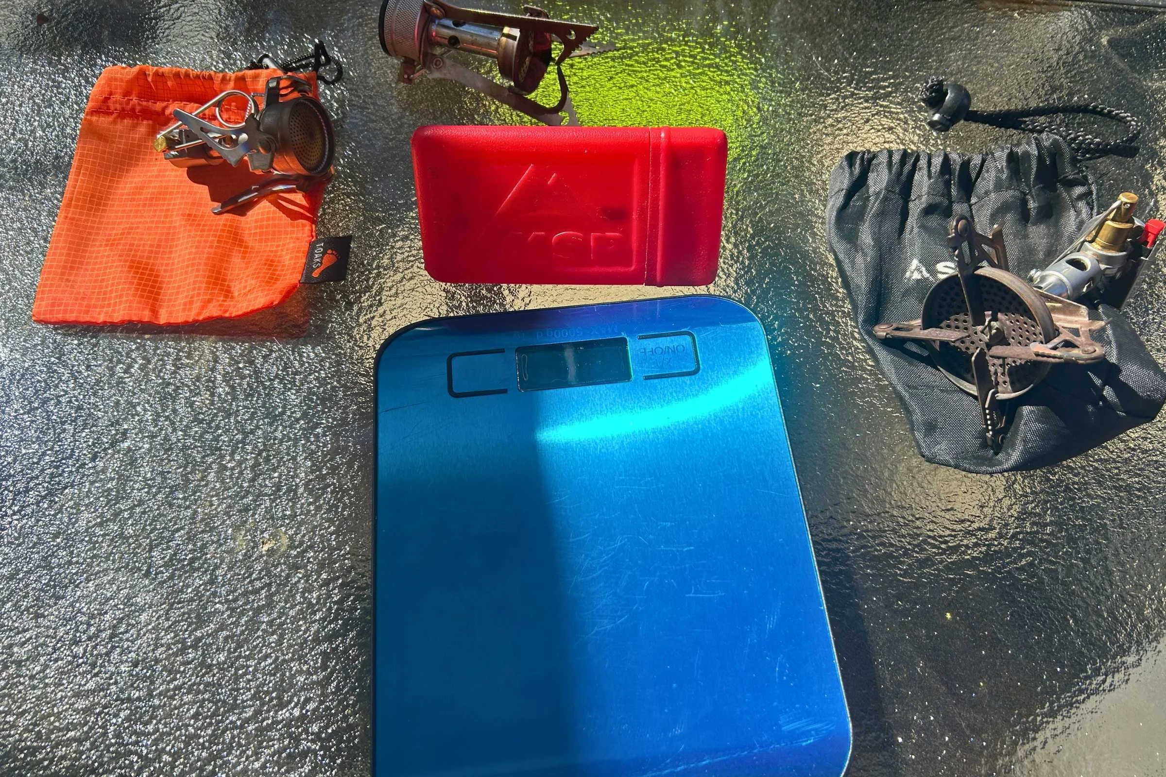 Testing several backpacking stoves using a scale for weight comparison