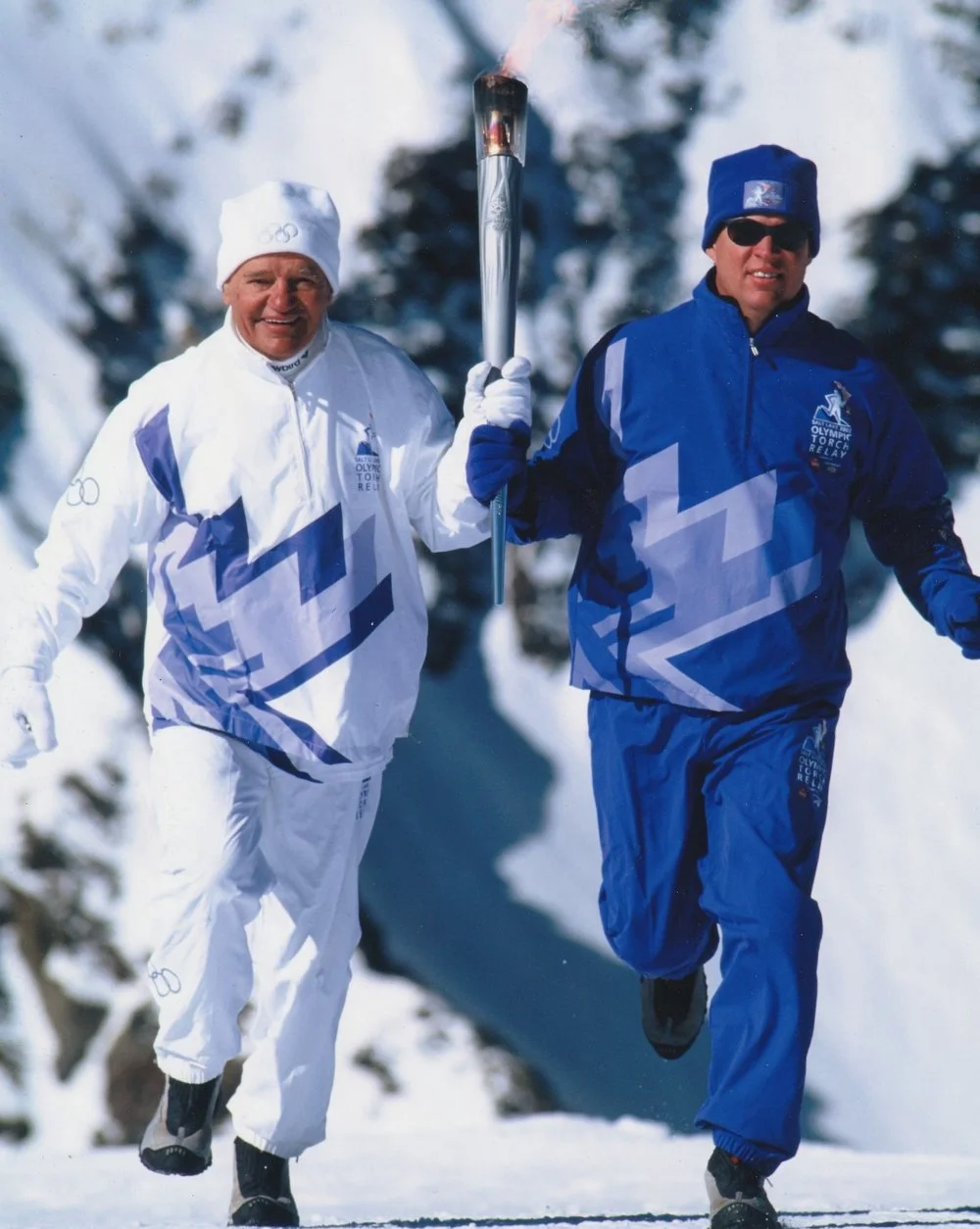   Junior Bounous and son Steve running with Junior's Olympic Torch on top of Hidden Peak at Snowbird in 2002.  &nbsp;Photo by James Kay Photography.  