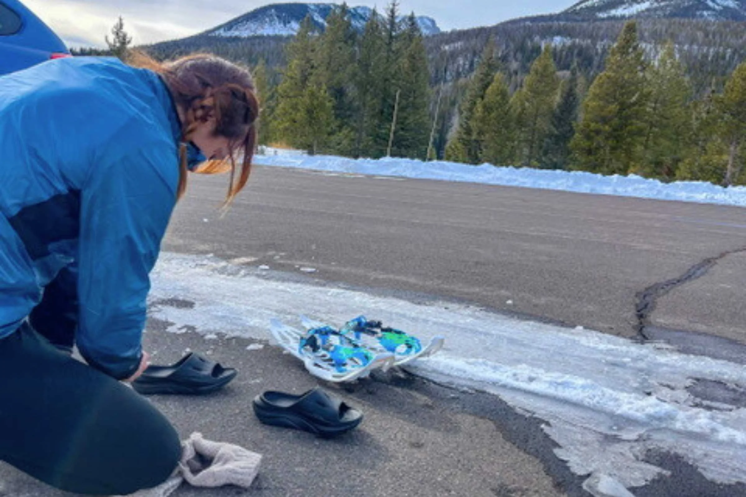 The author putting on Hoka Ora recovery slides after a snowshoe run in Rocky Mountain National Park.