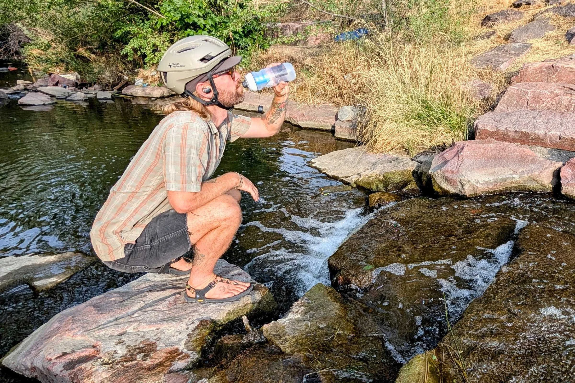 Drinking out of the Hydrapak Breakaway+ next to a stream