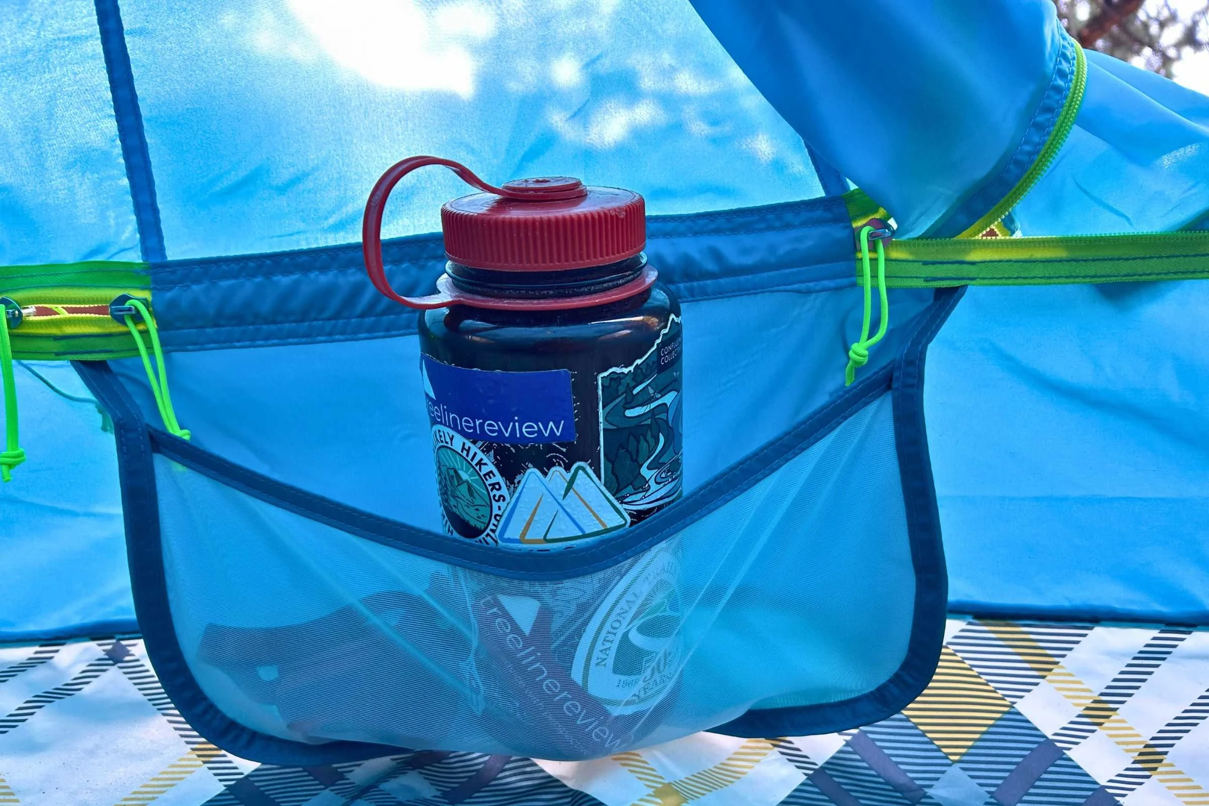 Nalgene water bottle and headlamp inside one of the gear pockets in the NEMO Aurora Highrise camping tent