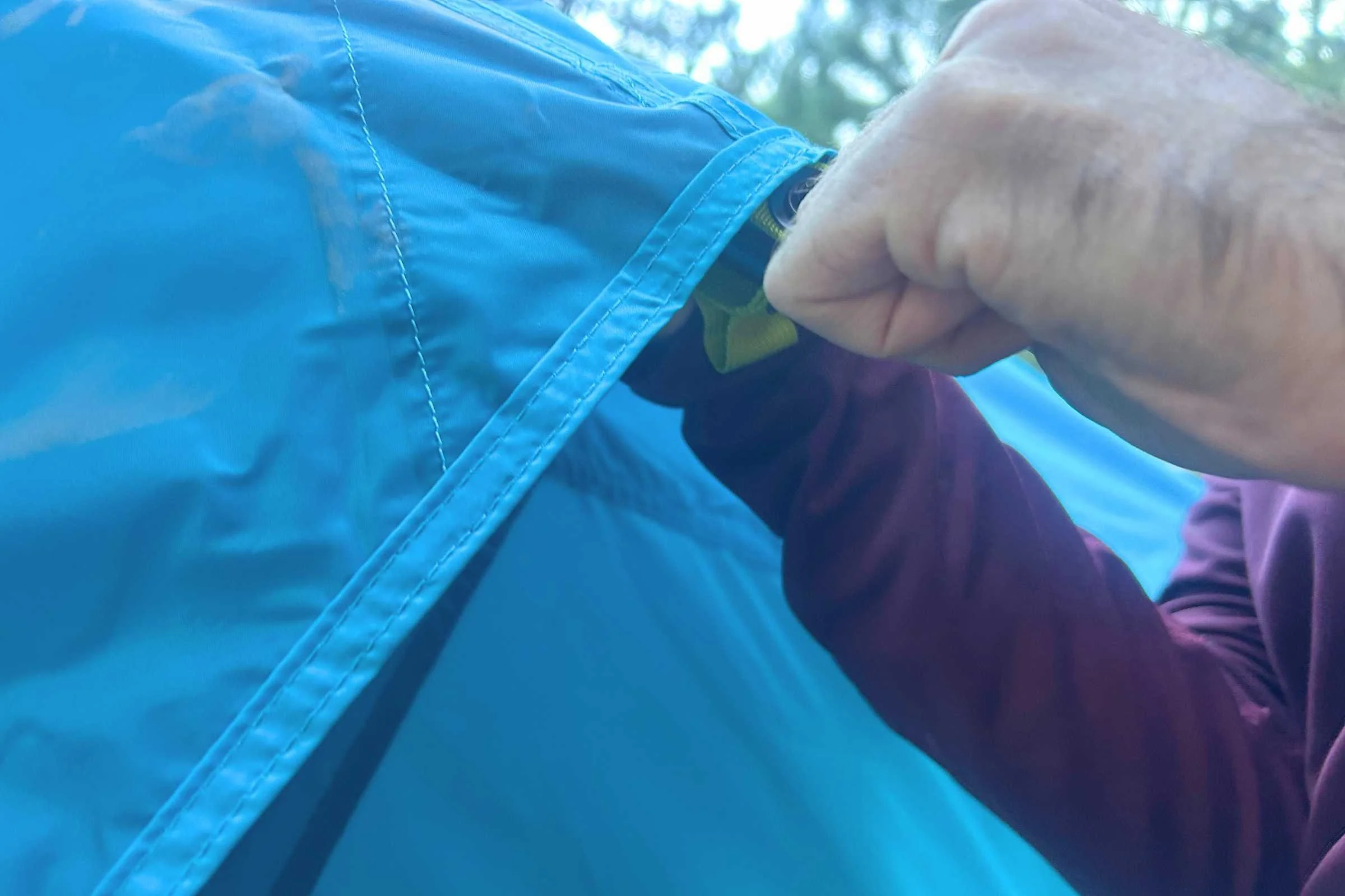 Camper setting up the rainfly on the NEMO Aurora Highrise camping tent
