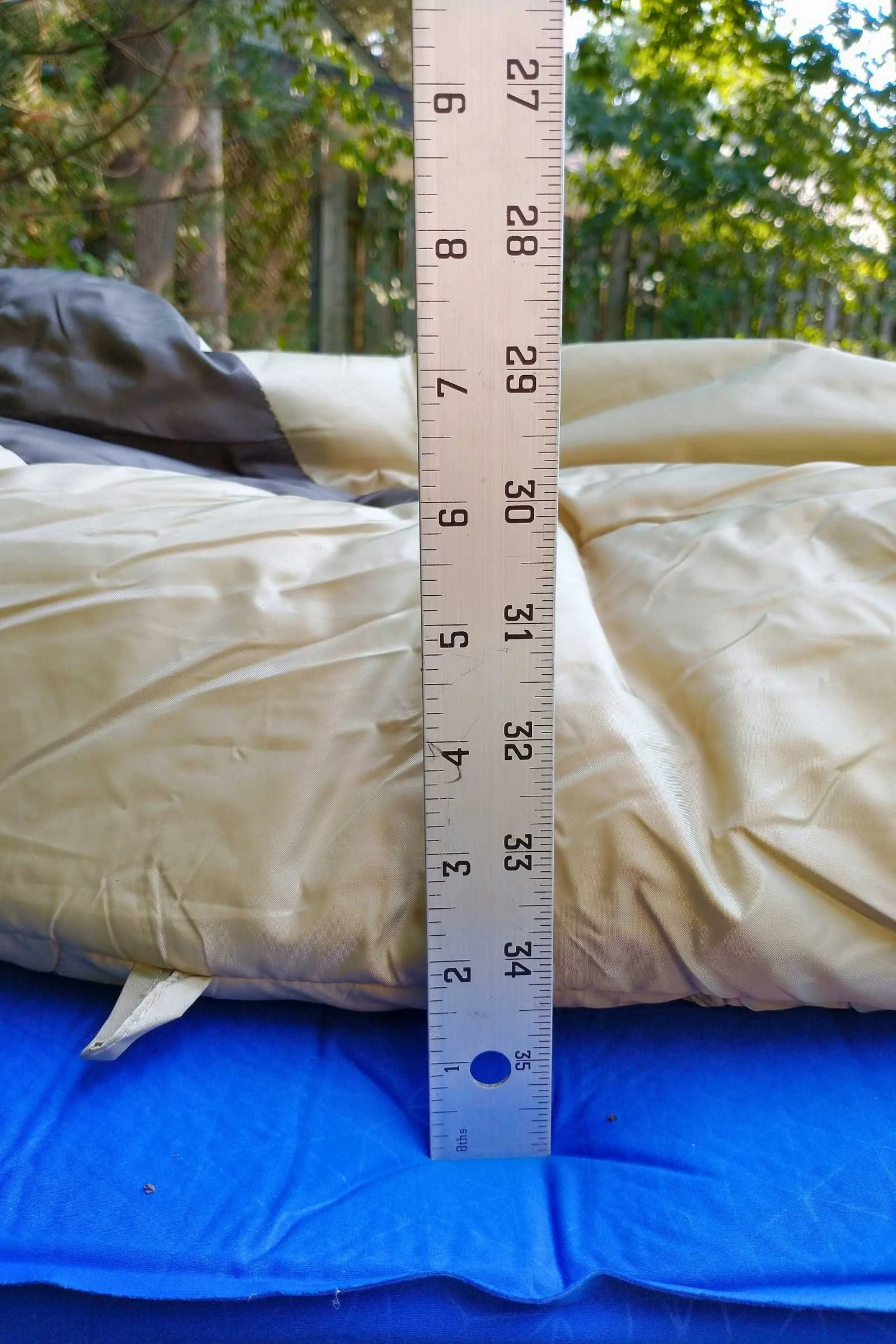Sea to Summit Comfort Deluxe sleeping pad with lowfty blanket on top with a ruler showing the thickness of the blacket