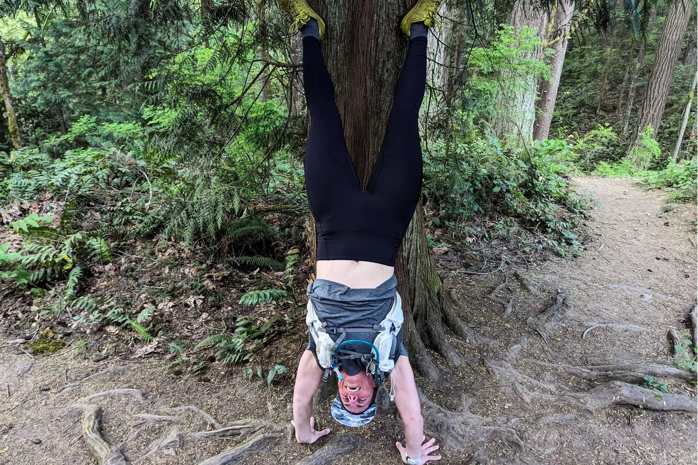  Woman doing a handstand on the trail while wearing the Arc’teryx Rho bottoms  