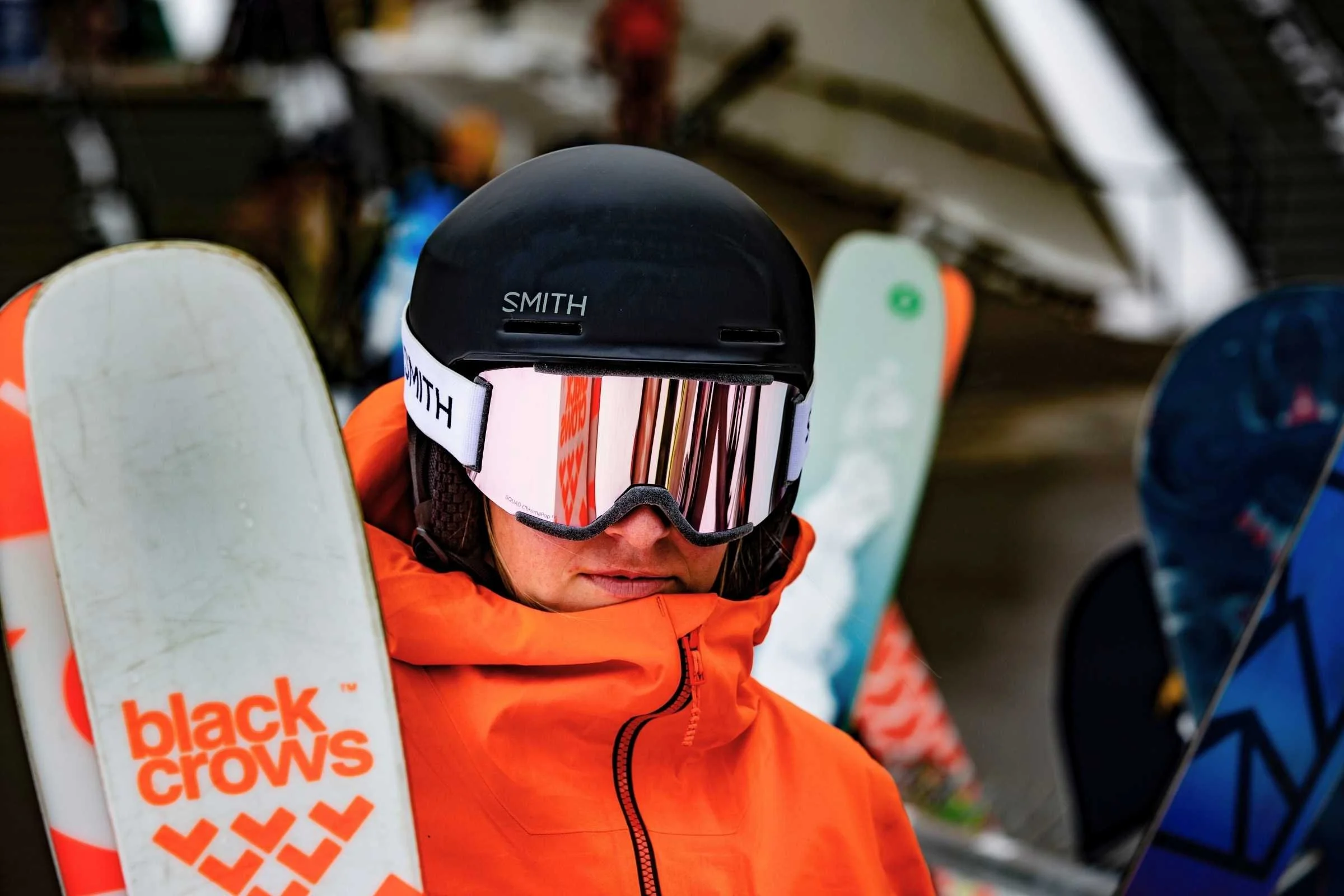   Skier wearing Outdoor Research Hemispheres Team 3L jacket holding skis  