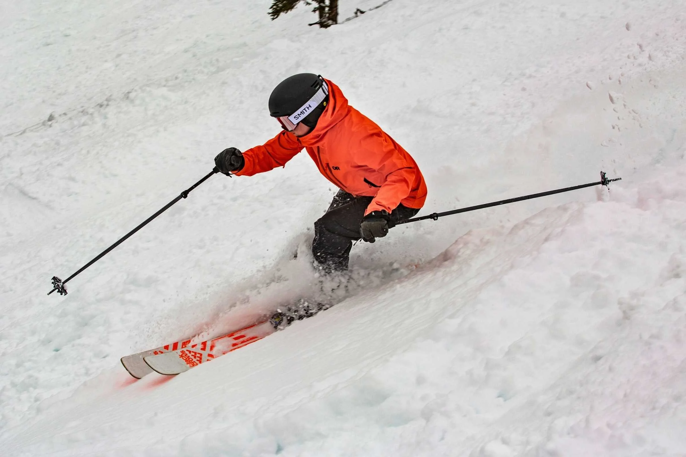   Skier turning downhill in Outdoor Research Hemispheres Team 3L jacket  