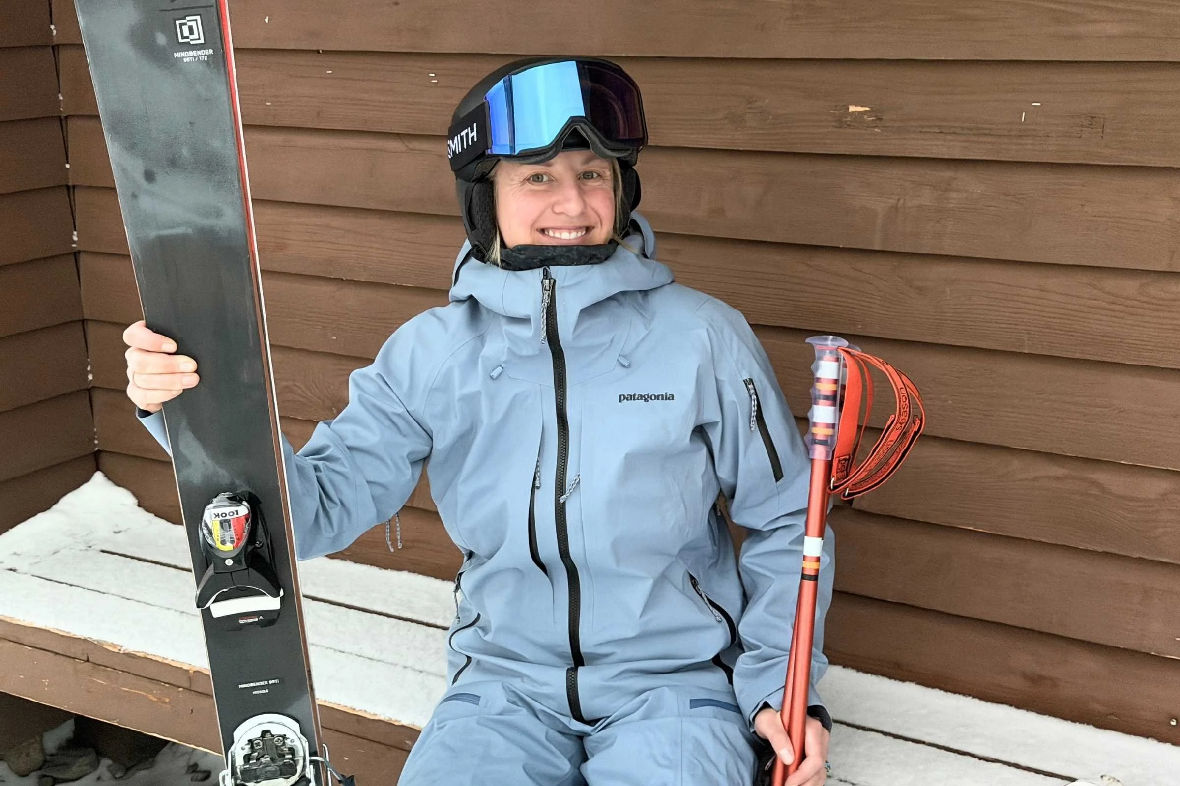   Skier holding skis wearing Patagonia PowSlayer jacket  