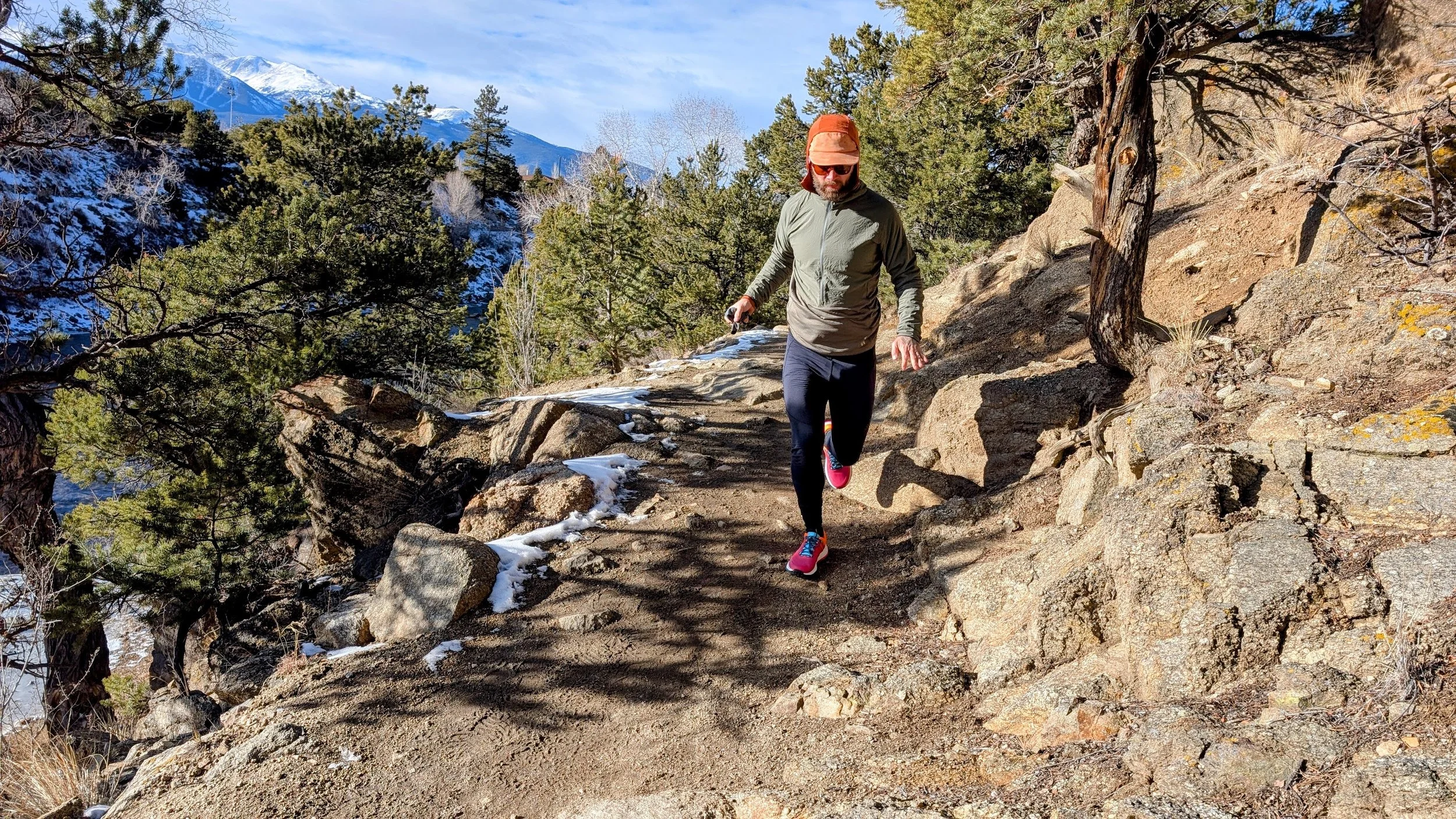   Trail runner wearing Craft Xplor Pro shoes navigating a rocky gravel trail in the mountains.  