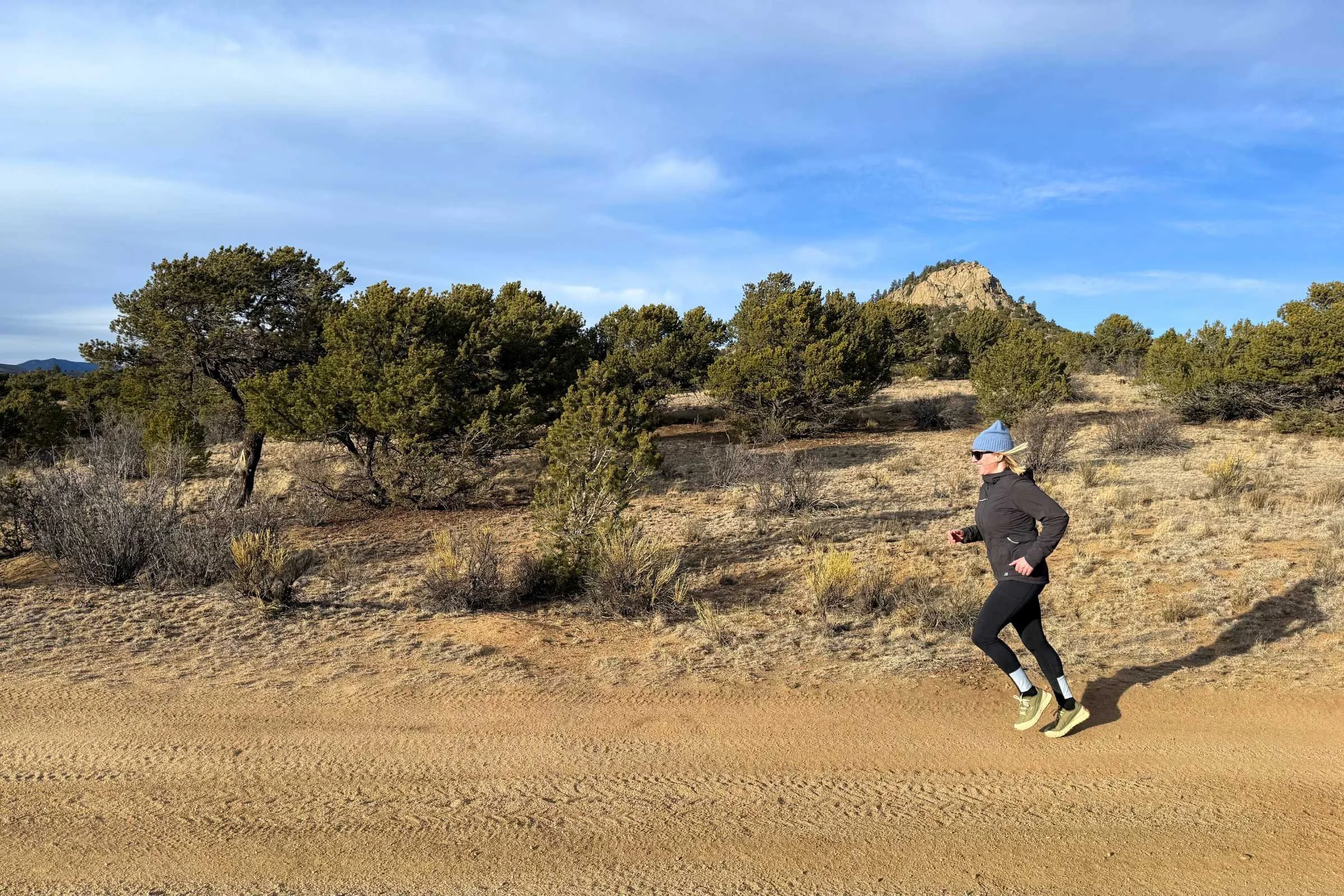   Runner testing the Oiselle Fireglow Fleece Tights on a dirt trail  