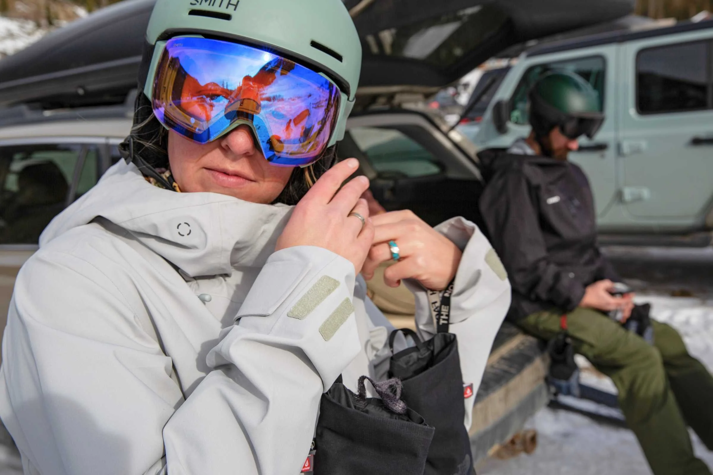   Skier adjusting chin strap wearing Smith Method MIPS helmet and goggles  