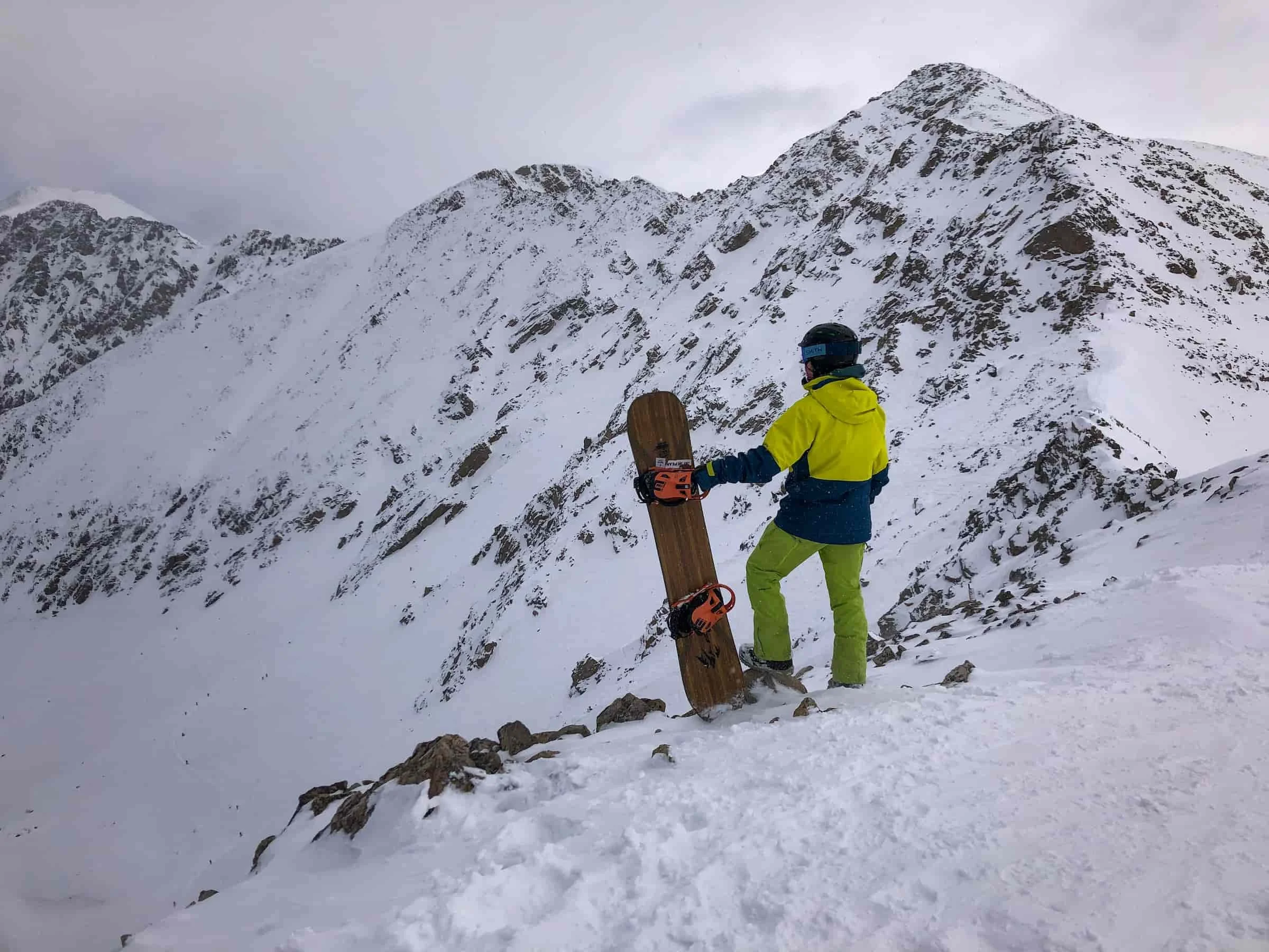   Snowboarder standing on ridgeline in Patagonia 3-in-1 Powder Town jacket  