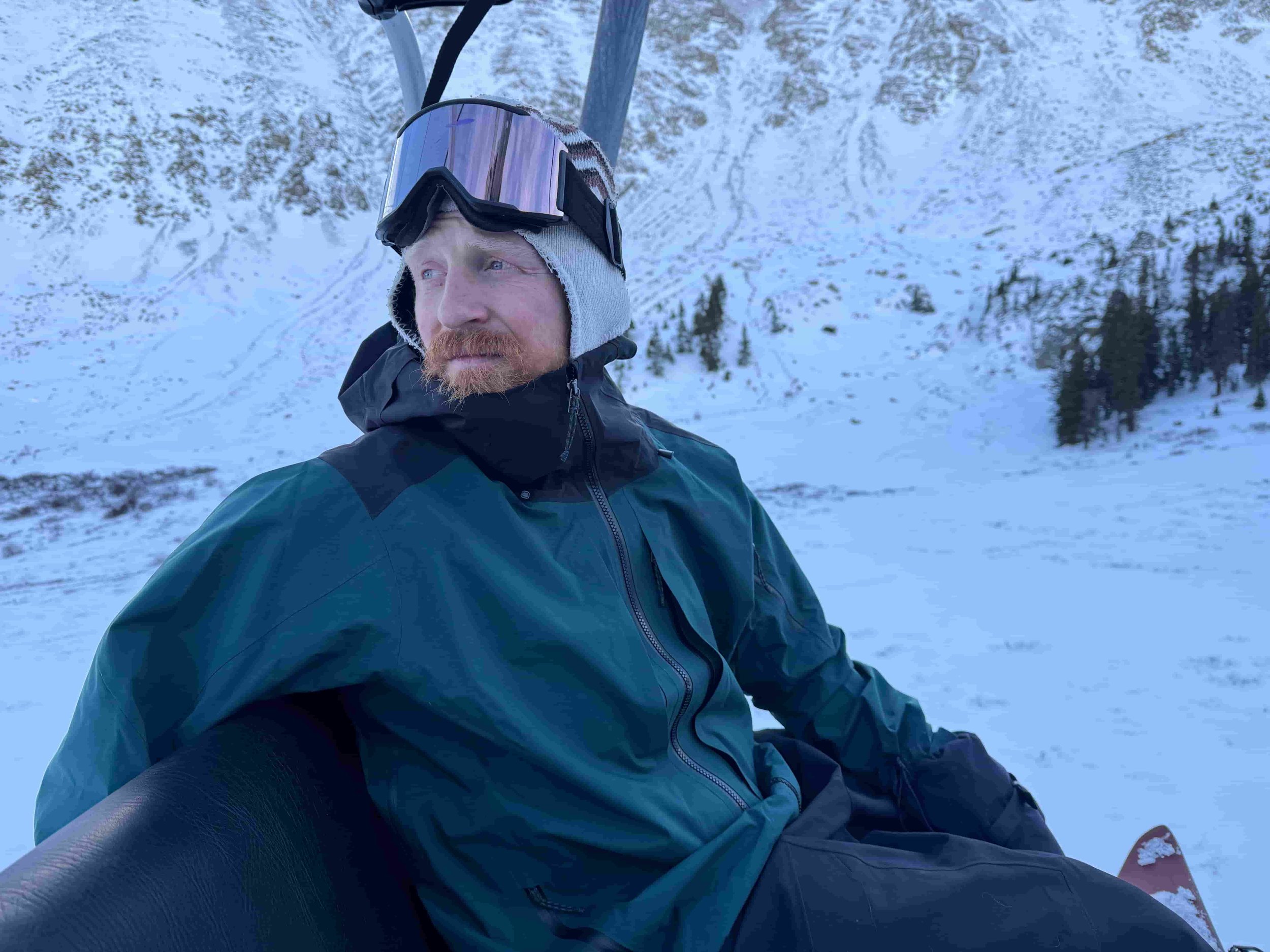   Skier sitting in snow wearing Patagonia PowSlayer jacket  