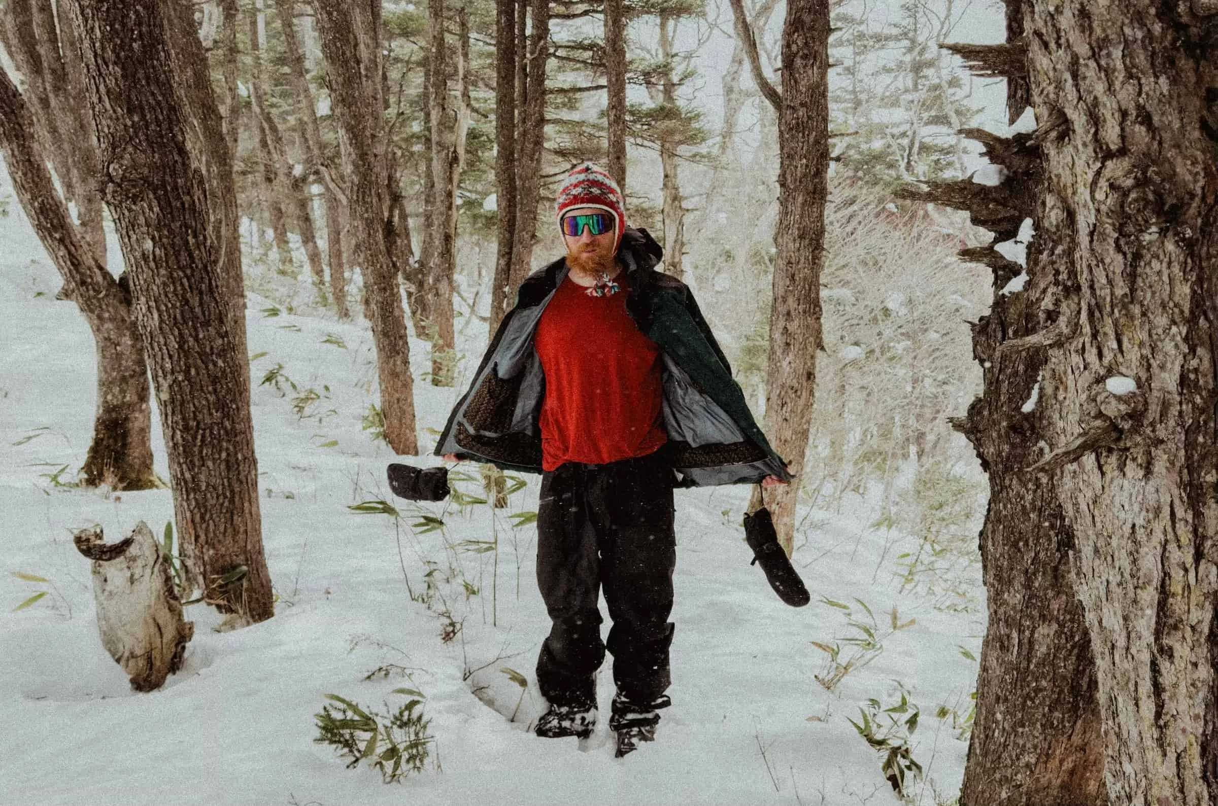   Man in snowy forest wearing Patagonia PowSlayer jacket open  